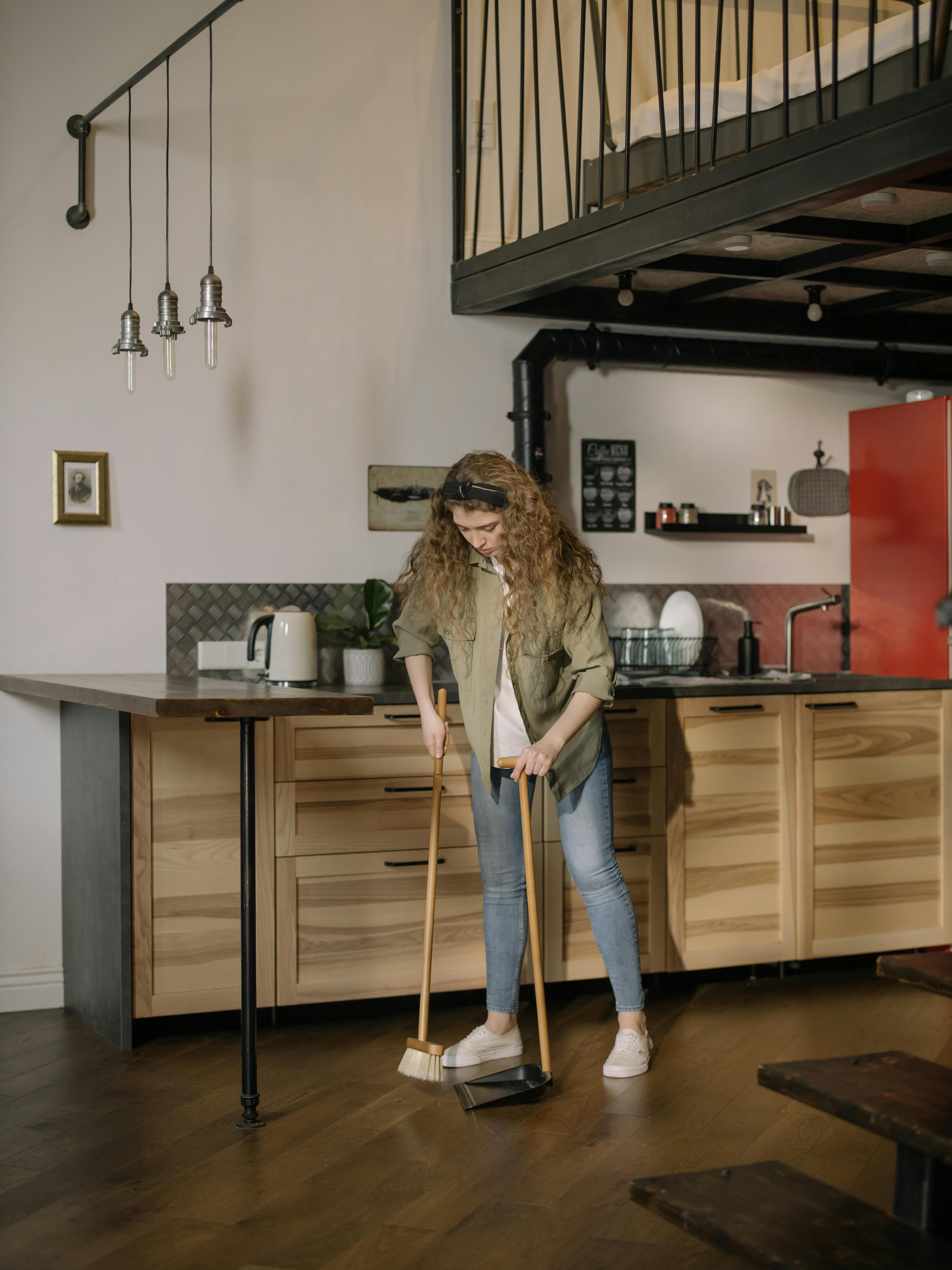 Una mujer barriendo el suelo | Fuente: Pexels