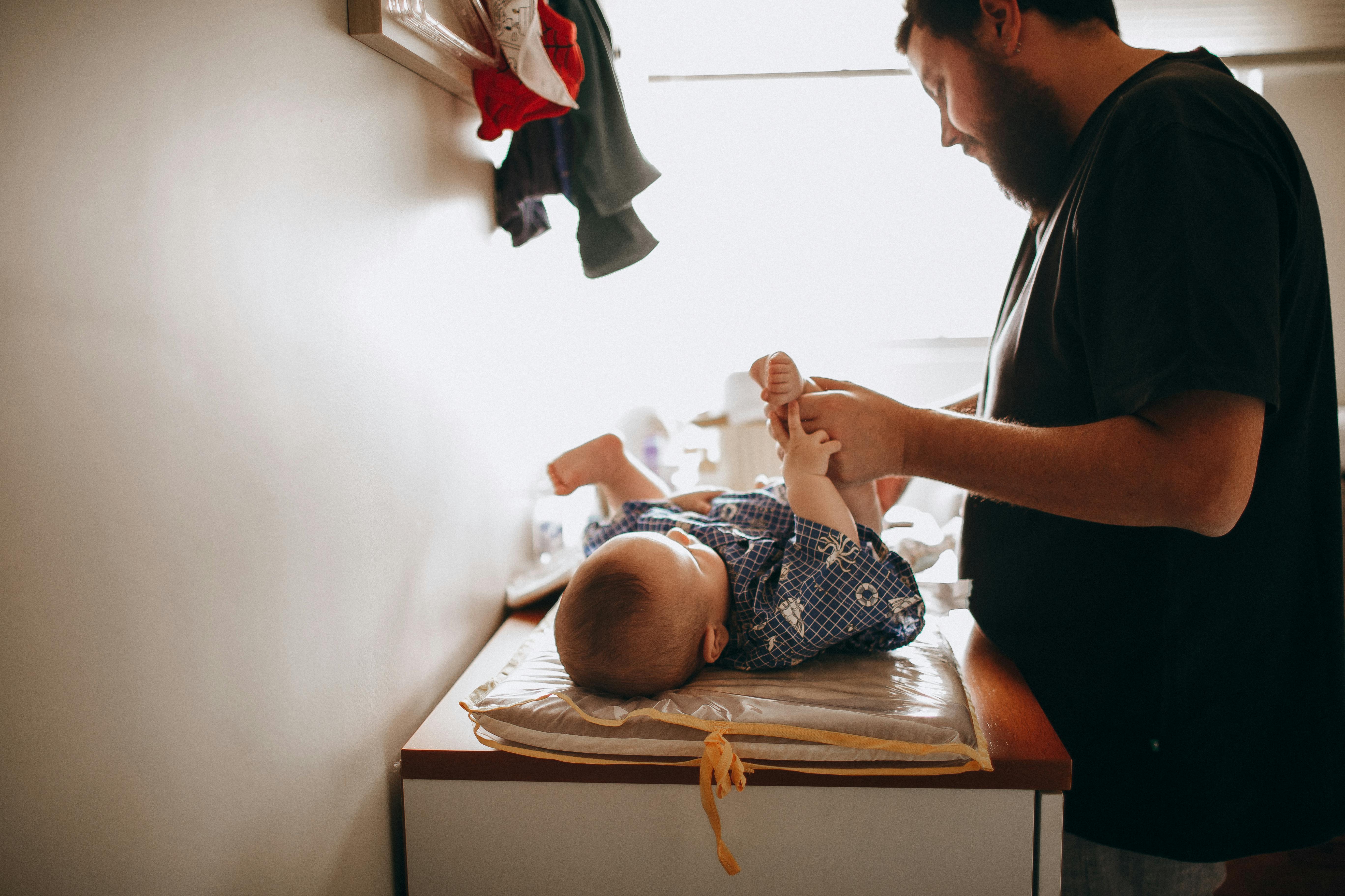 Un padre cambiando el pañal a un bebé | Fuente: Pexels