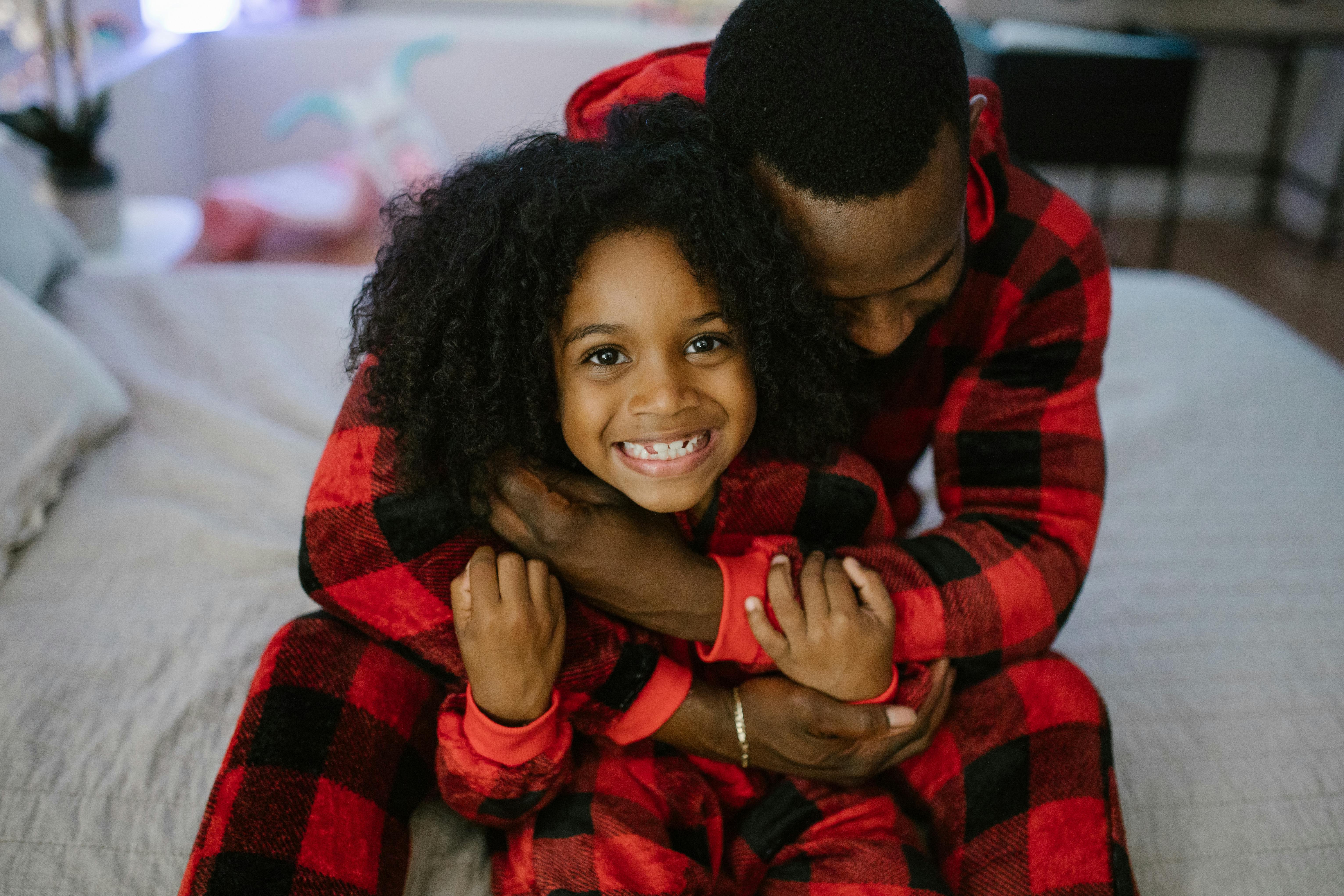 Hombre abraza a su hija con un pijama a juego | Foto: Pexels