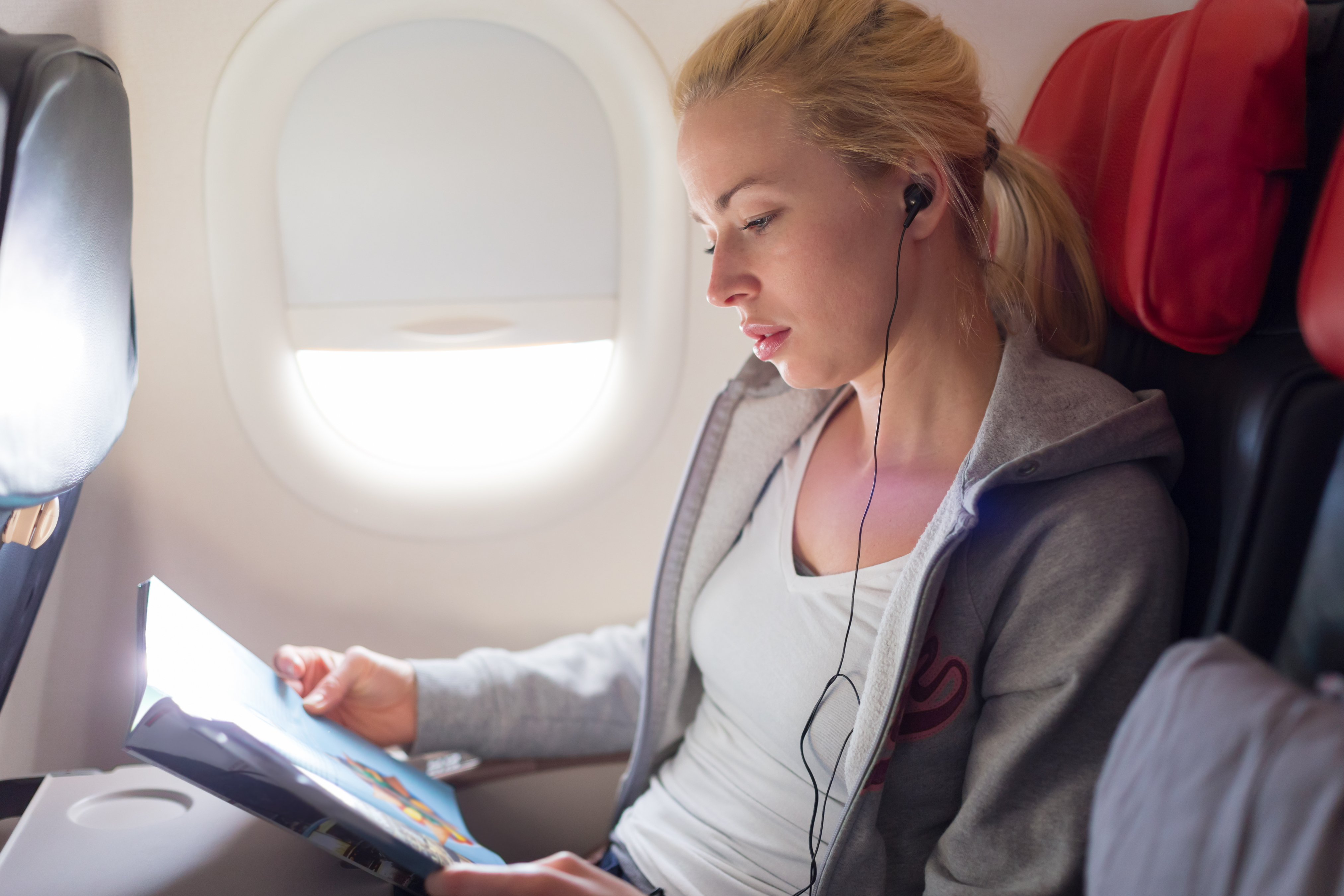 Joven leyendo durante un vuelo | Fuente: Pexels