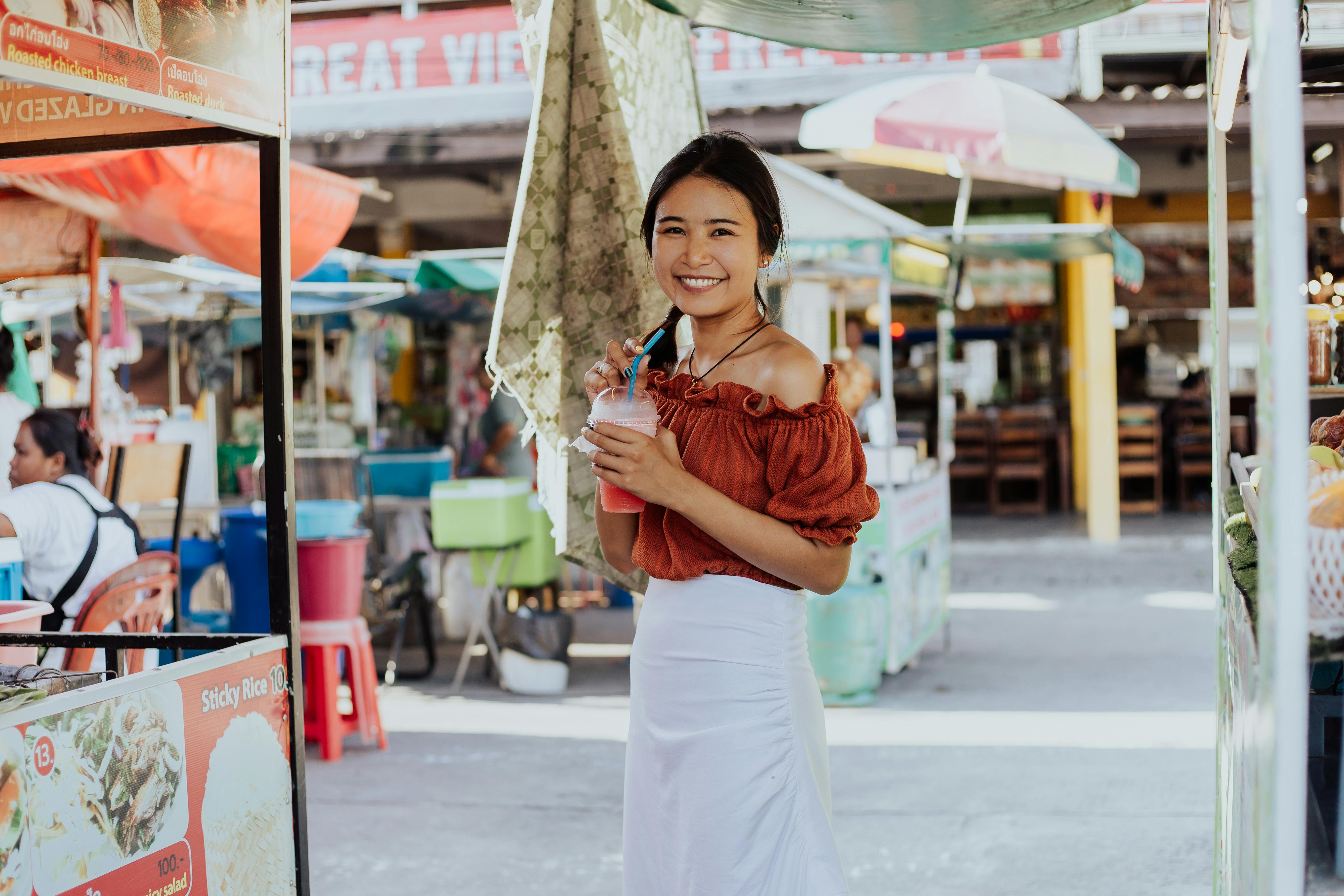 Mujer sonriendo mientras sostiene un batido | Fuente: Pexels