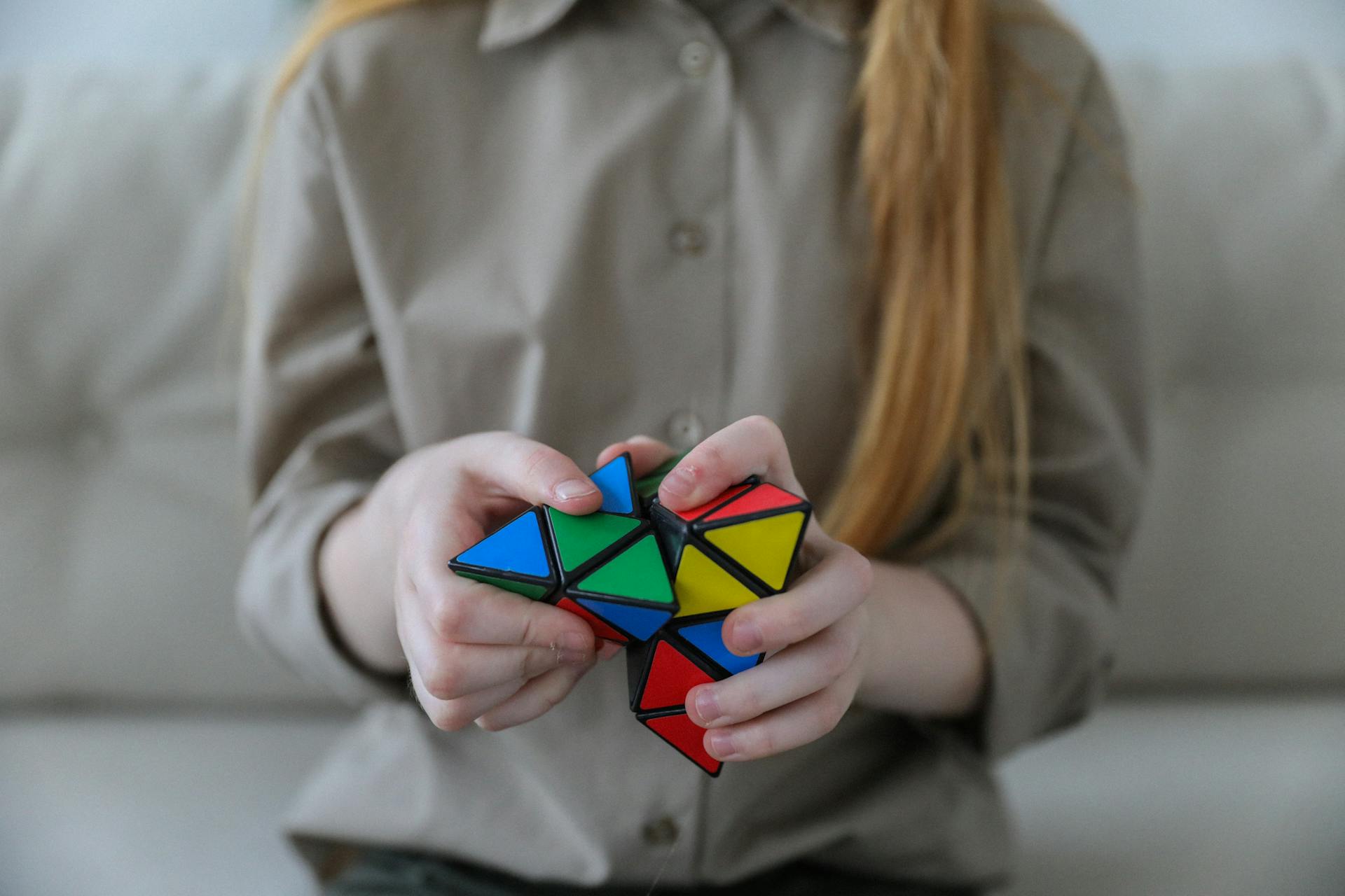 Una niña resolviendo un Pyraminx | Fuente: Pexels