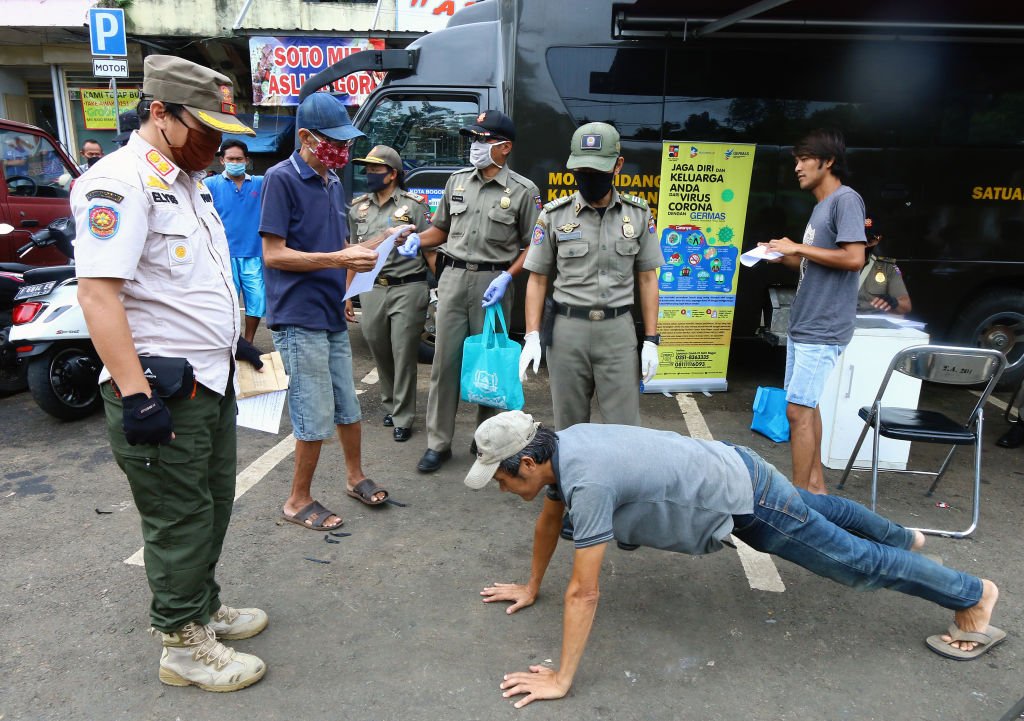 Ciudadano cumple sentencia de hacer flexiones por no usar una máscara. Abril, 2020, Bogor, Indonesia. | Foto: Getty Images