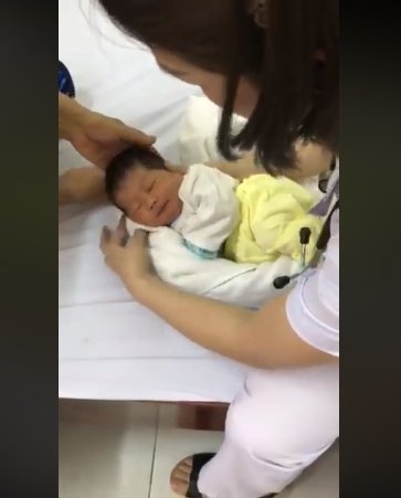 Enfermera aplicando una técnica para poner al bebé a dormir. Fuente: Facebook / Ánh Tít