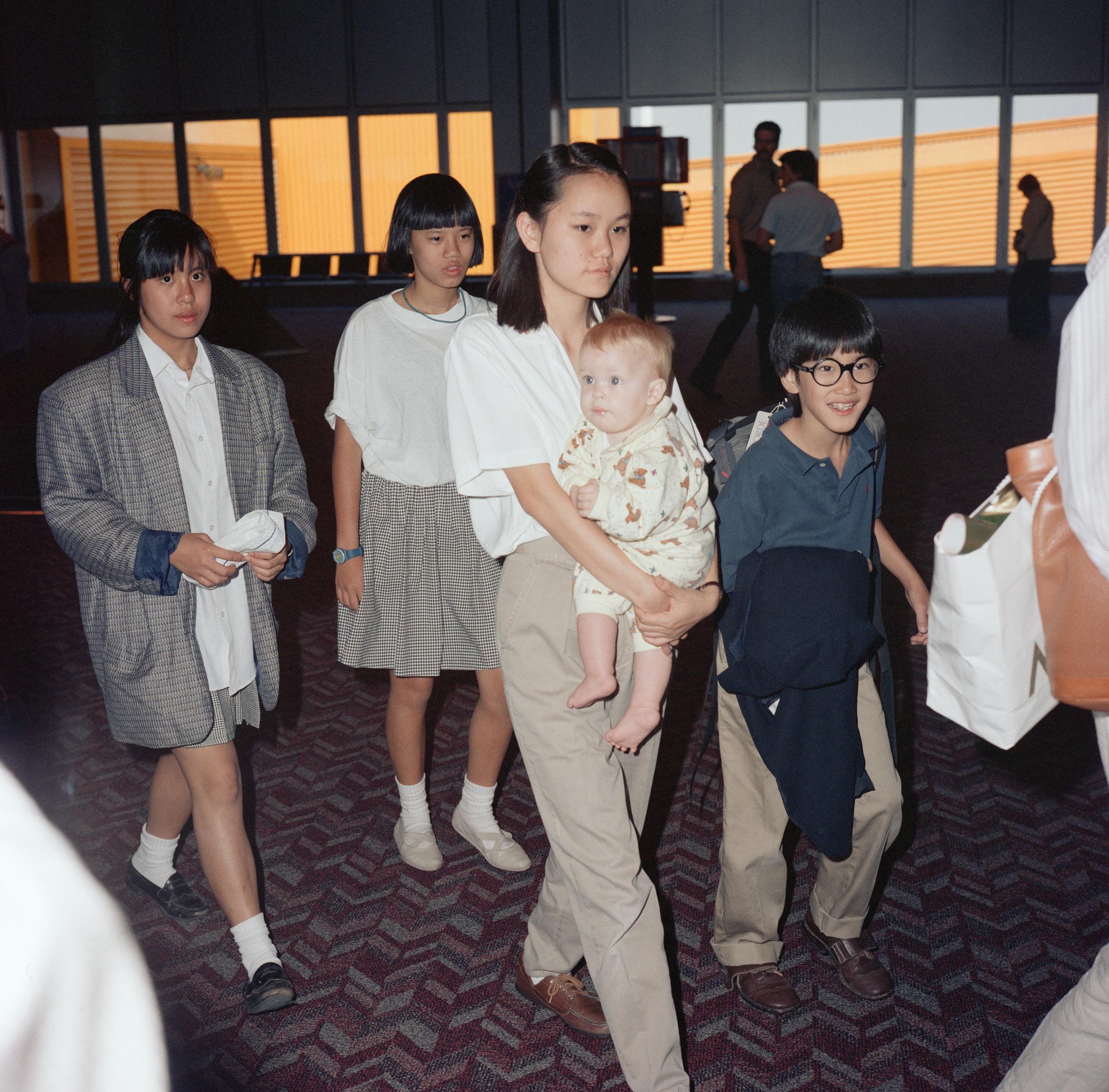 Woody Allen y Mia Farrow viajando con sus hijos en el aeropuerto londinense de Heathrow, el 8 de agosto de 1988. | Fuente: Getty Images