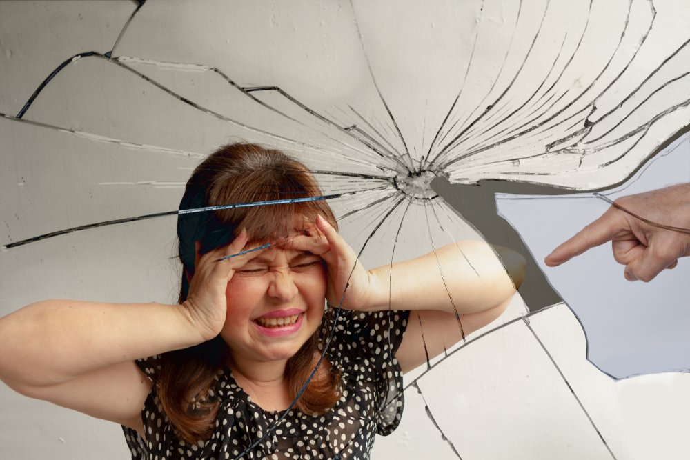 El reflejo de una mujer en un espejo roto. | Foto: Shutterstock
