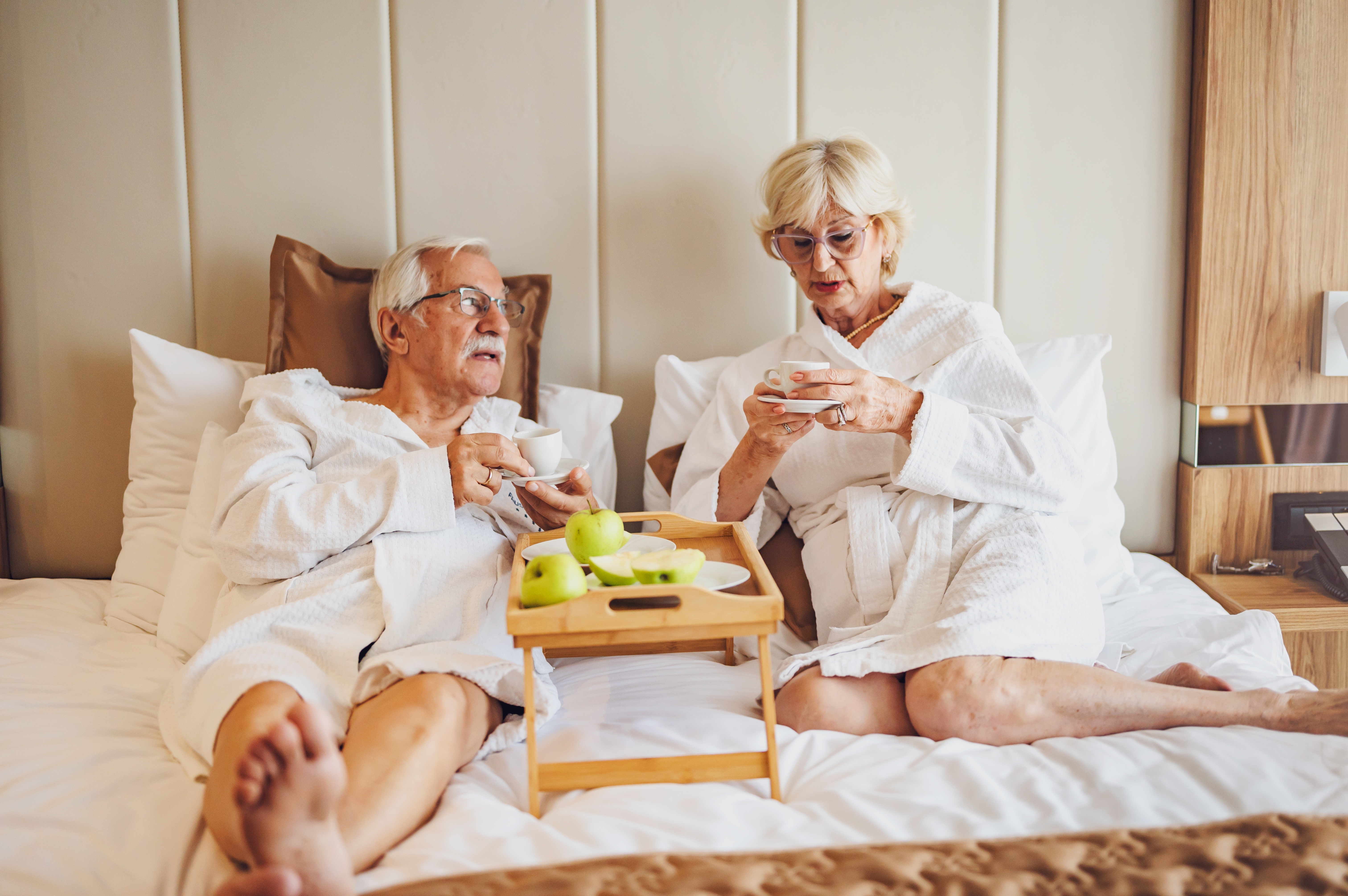 Una pareja de ancianos tomando café en una habitación de hotel | Fuente: Shutterstock