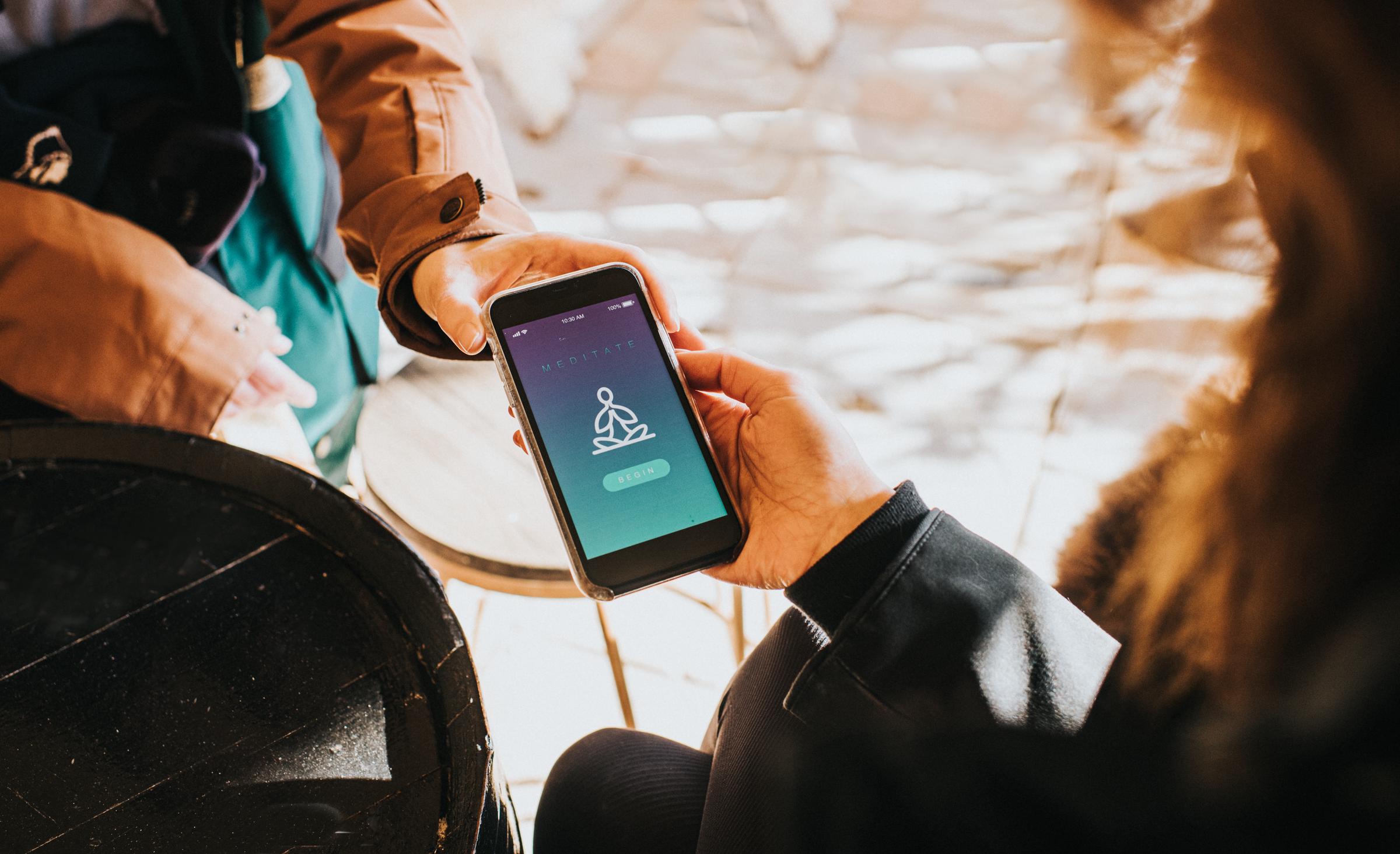Una persona utilizando una aplicación de meditación en el teléfono | Fuente: Getty Images
