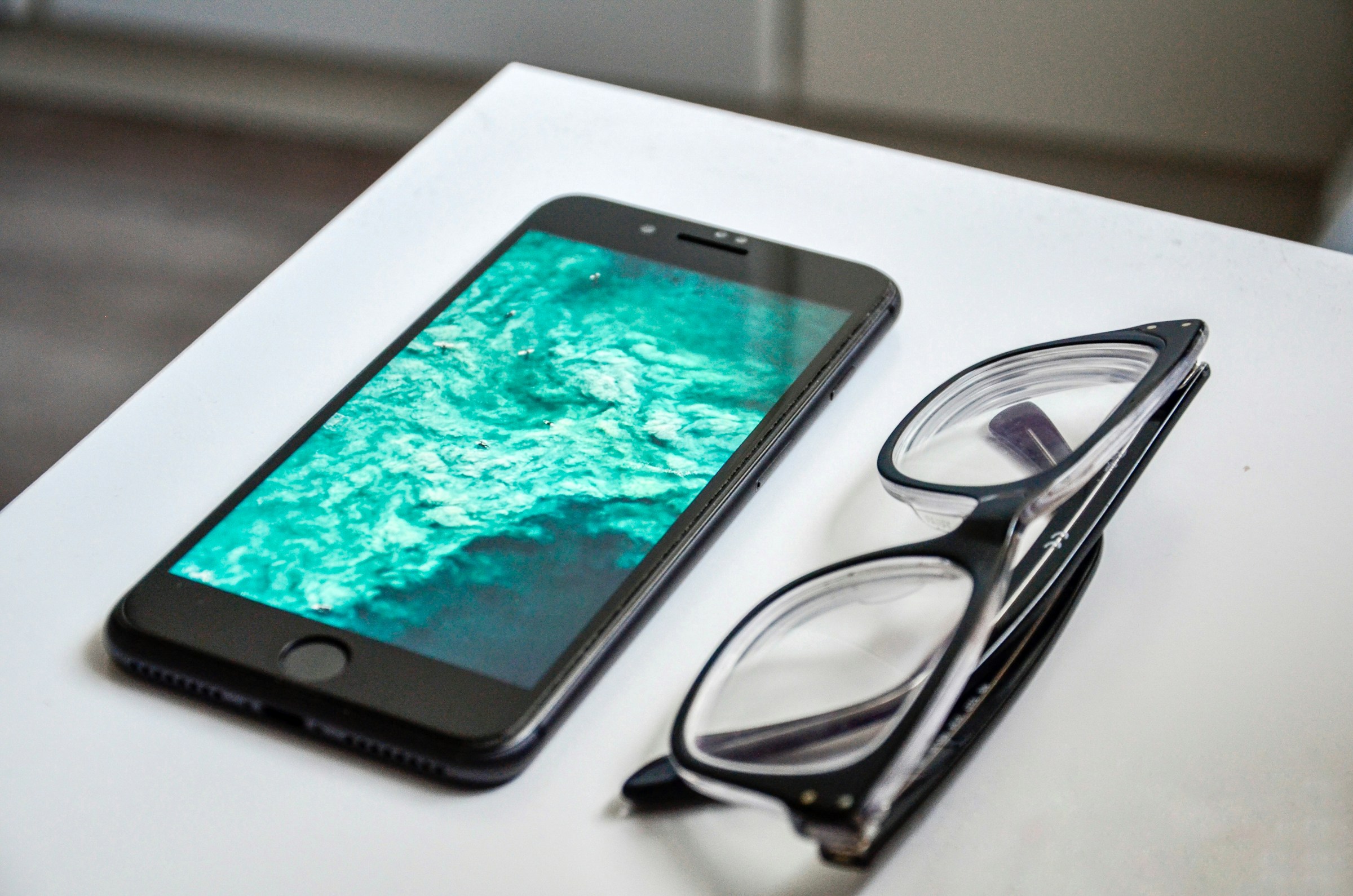 Un smartphone y unas gafas sobre una mesa | Fuente: Unsplash