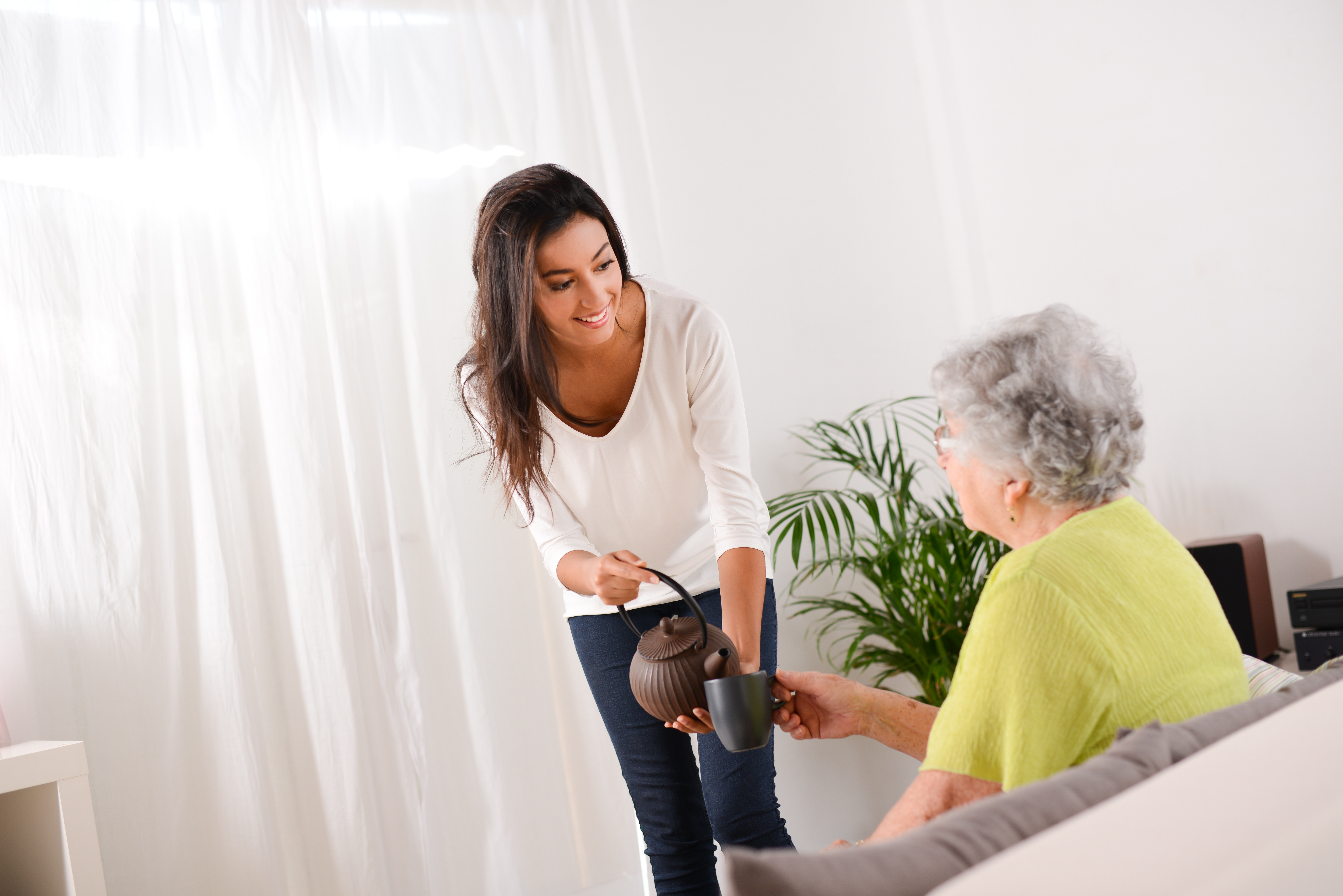 Una mujer llevando té a una anciana | Foto: Shutterstock