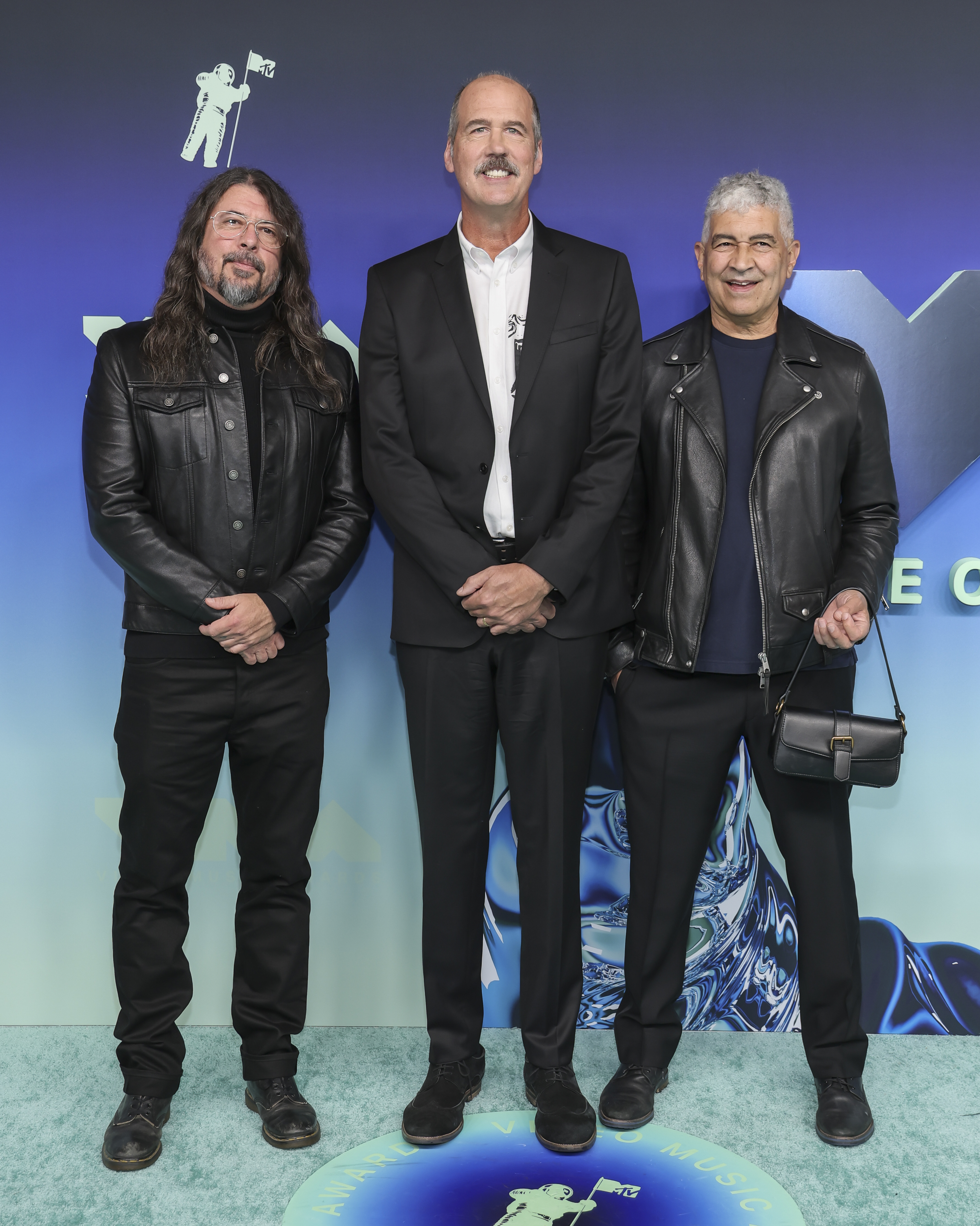 Grohl, Novoselic y Smear posaron juntos con un look a juego en tonos oscuros, con chaquetas de cuero que contrastaban con el traje negro y la camisa blanca de Novoselic. El trío mantuvo su estilo para los VMA fiel a los trajes negros y los clásicos del rock. | Fuente: Getty Images