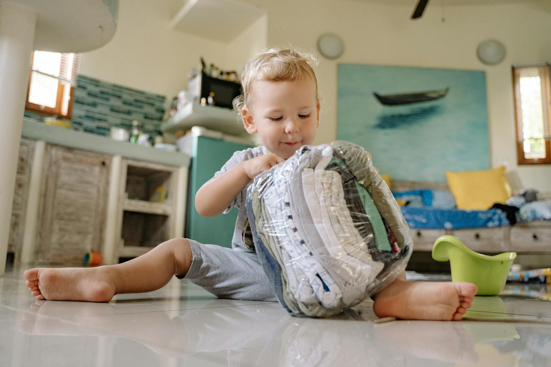 Un niño jugando con ropa en una bolsa de plástico | Fuente: Pexels