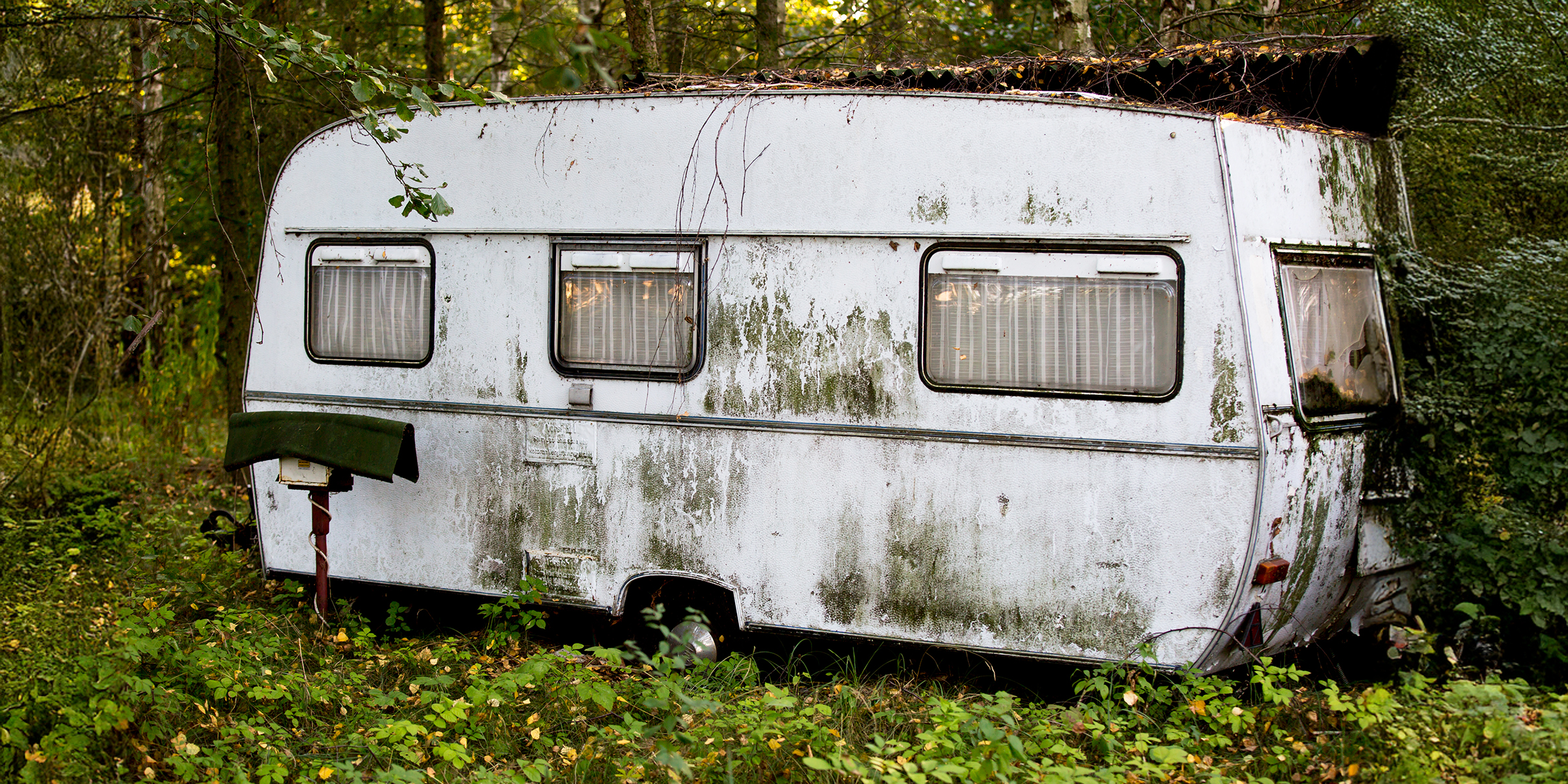 Una vieja caravana en el bosque | Fuente: Midjourney