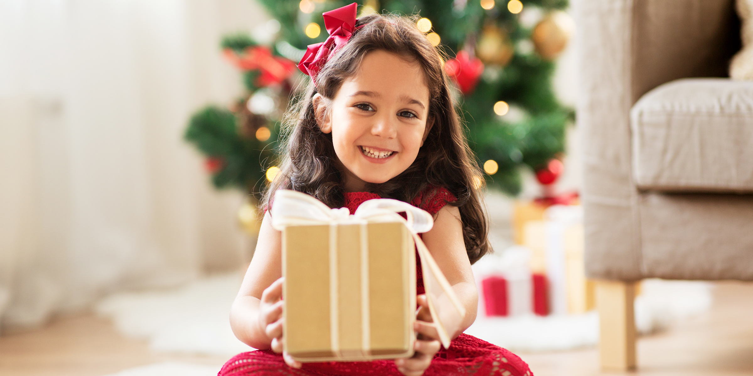 Una niña con un regalo en la mano | Fuente: Shutterstock