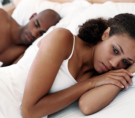 Esposa alejándose de su marido en la cama, aparentemente preocupada. Fuente: Flickr