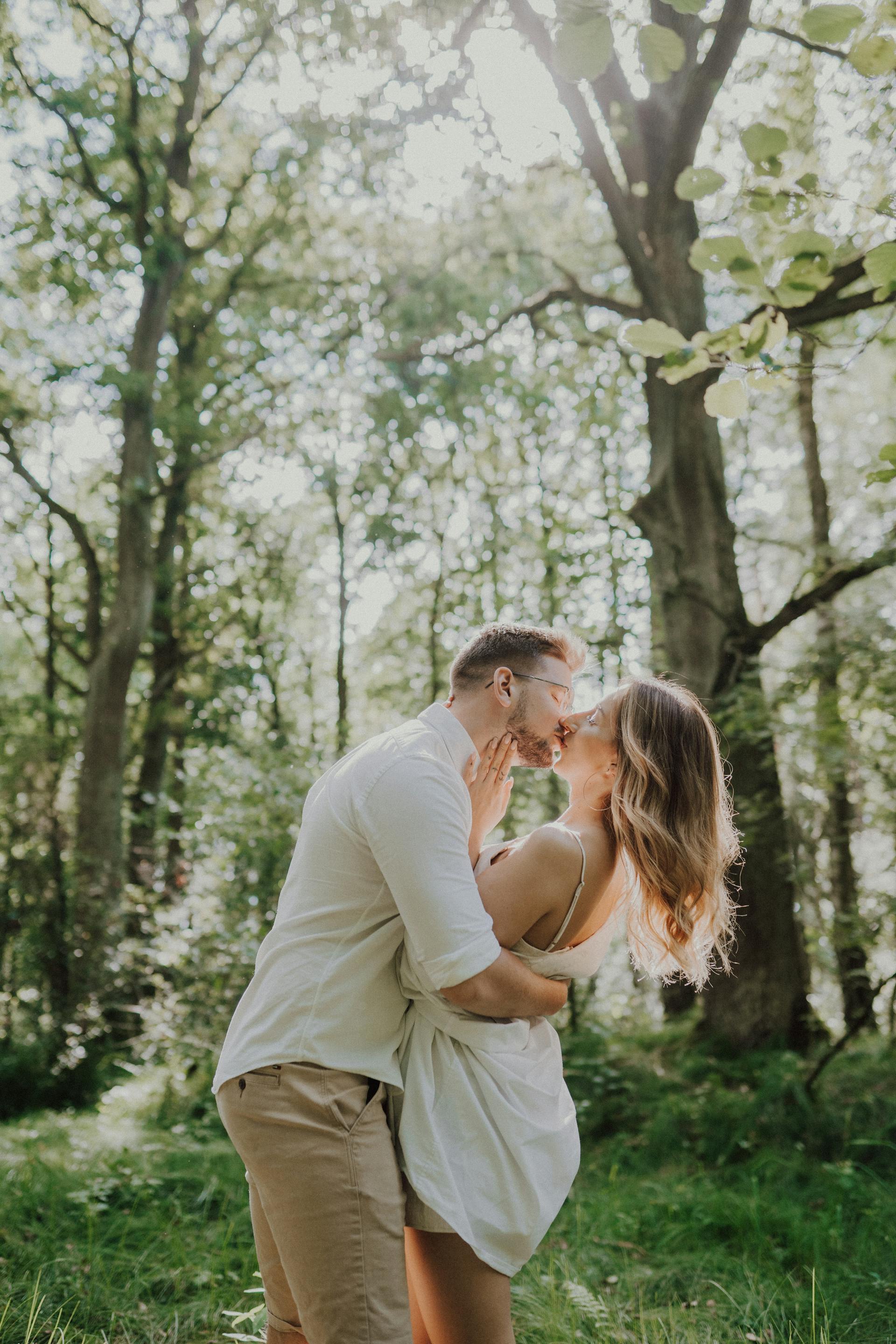 Una joven pareja besándose en un bosque | Fuente: Pexels