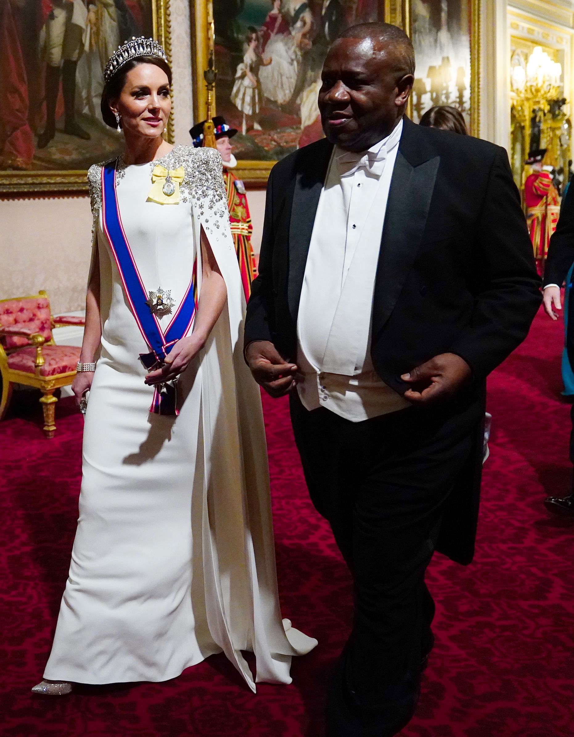 Catherine, princesa de Gales, llega al banquete de Estado en honor al presidente sudafricano Cyril Ramaphosa en el Palacio de Buckingham el 22 de noviembre de 2022, en su primera aparición en un banquete con ese título. Luce un vestido marfil con capa de Jenny Packham, hombros adornados con cristales, la tiara Lover's Knot de la reina Mary, pendientes de perlas de la princesa Diana y condecoraciones reales. | Fuente: Getty Images