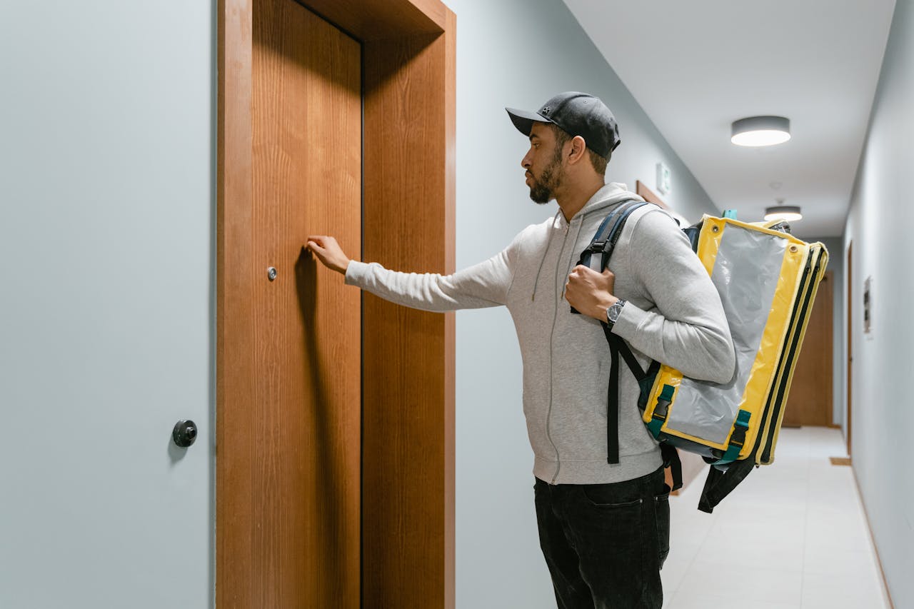 Un repartidor llamando a la puerta de una habitación de hotel | Fuente: Pexels