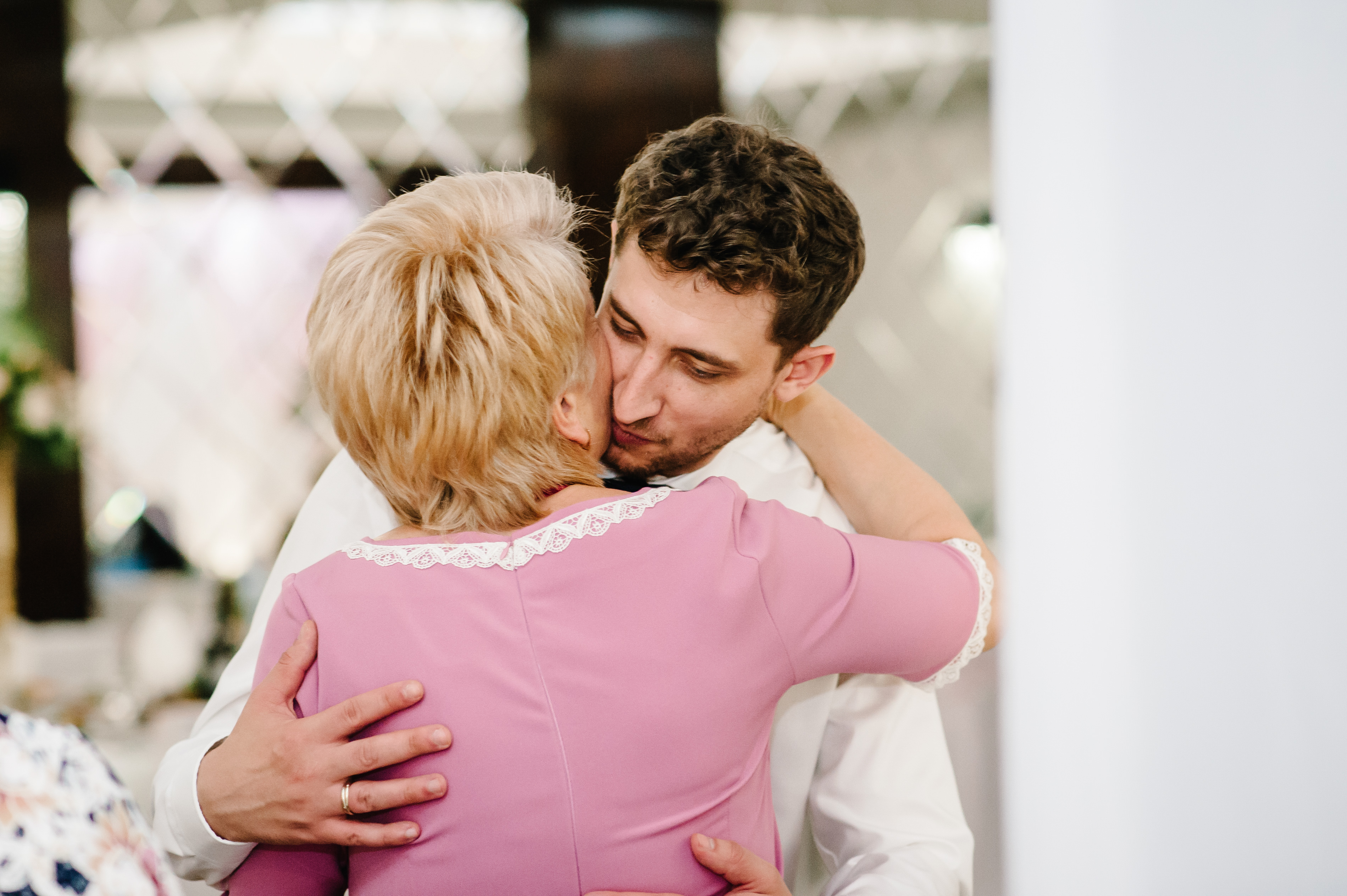 Um homem abraça e beija sua mãe na bochecha | Foto: Shutterstock