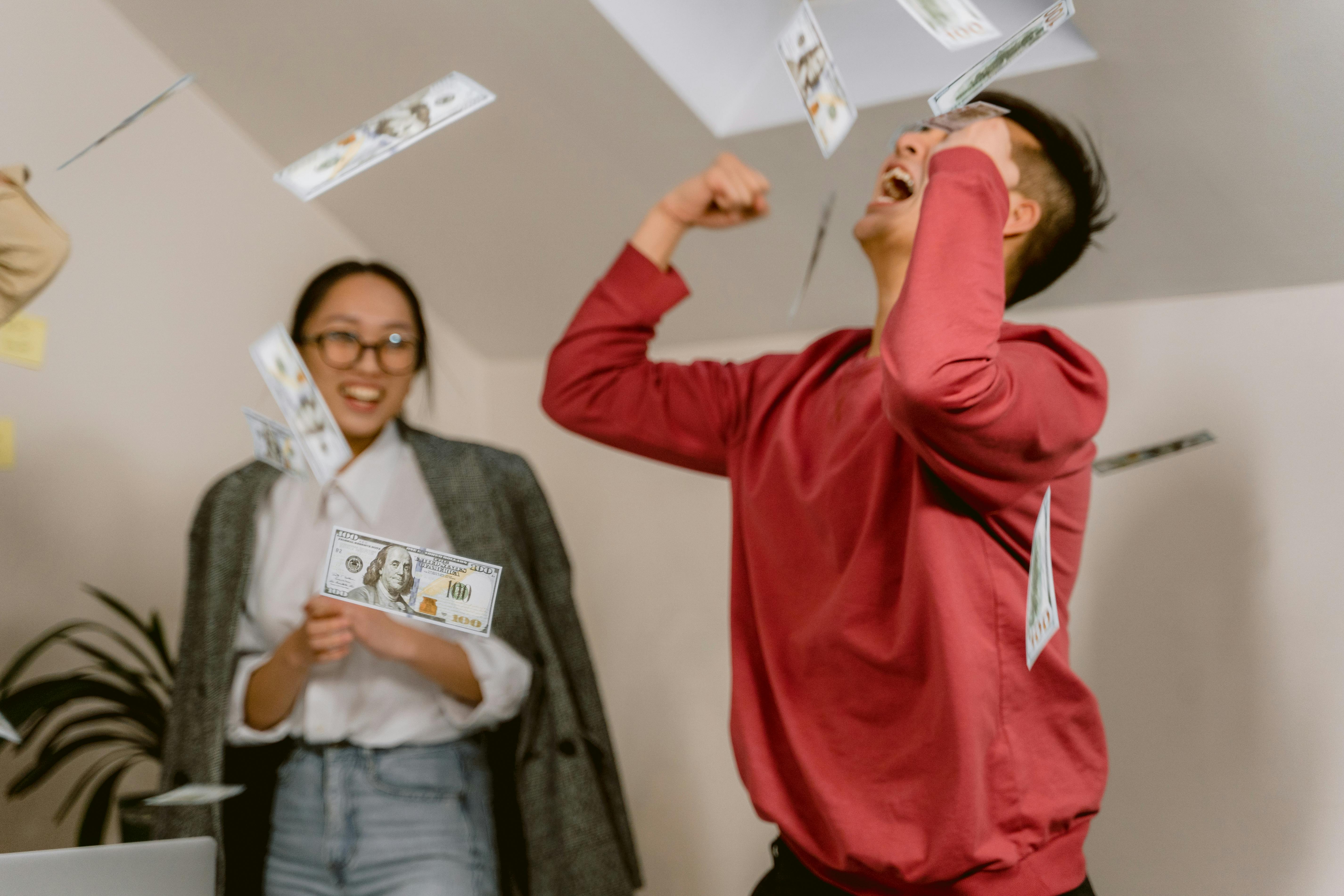 Mujer observa a un hombre que celebra lanzando dinero | Foto: Pexels