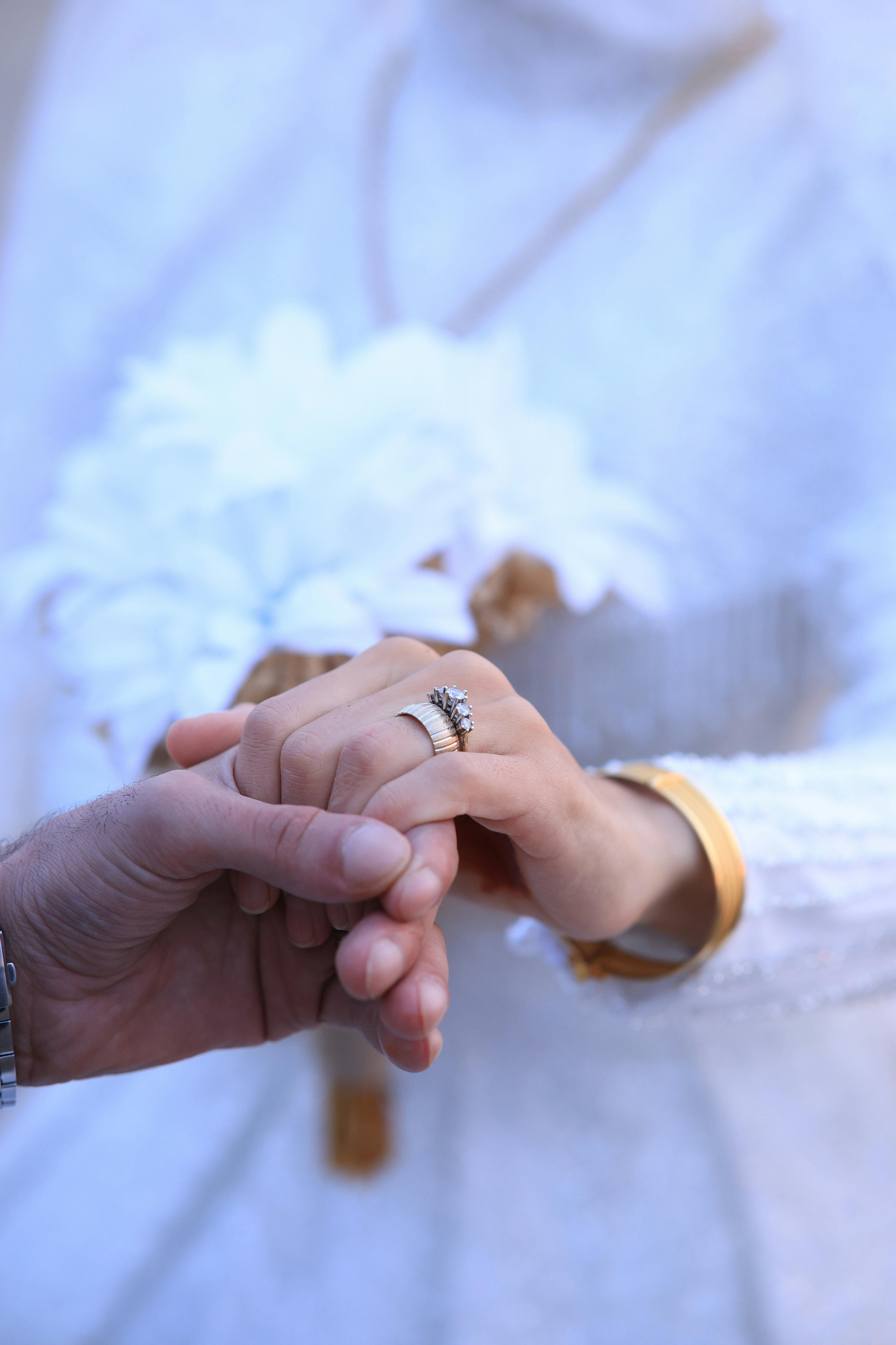 Recién casados cogidos de la mano | Fuente: Pexels