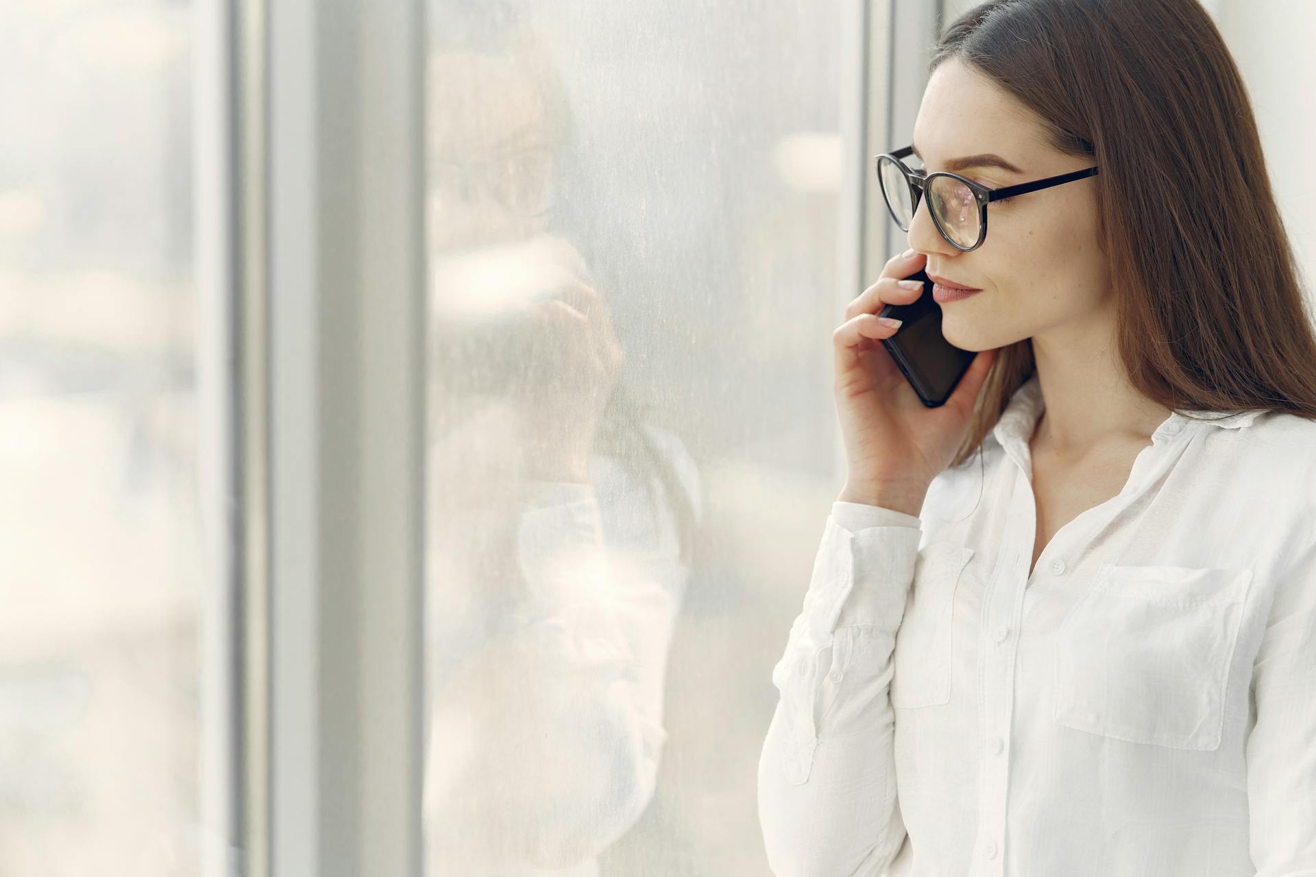 Una mujer sonriendo sombríamente durante una llamada telefónica | Fuente: Pexels