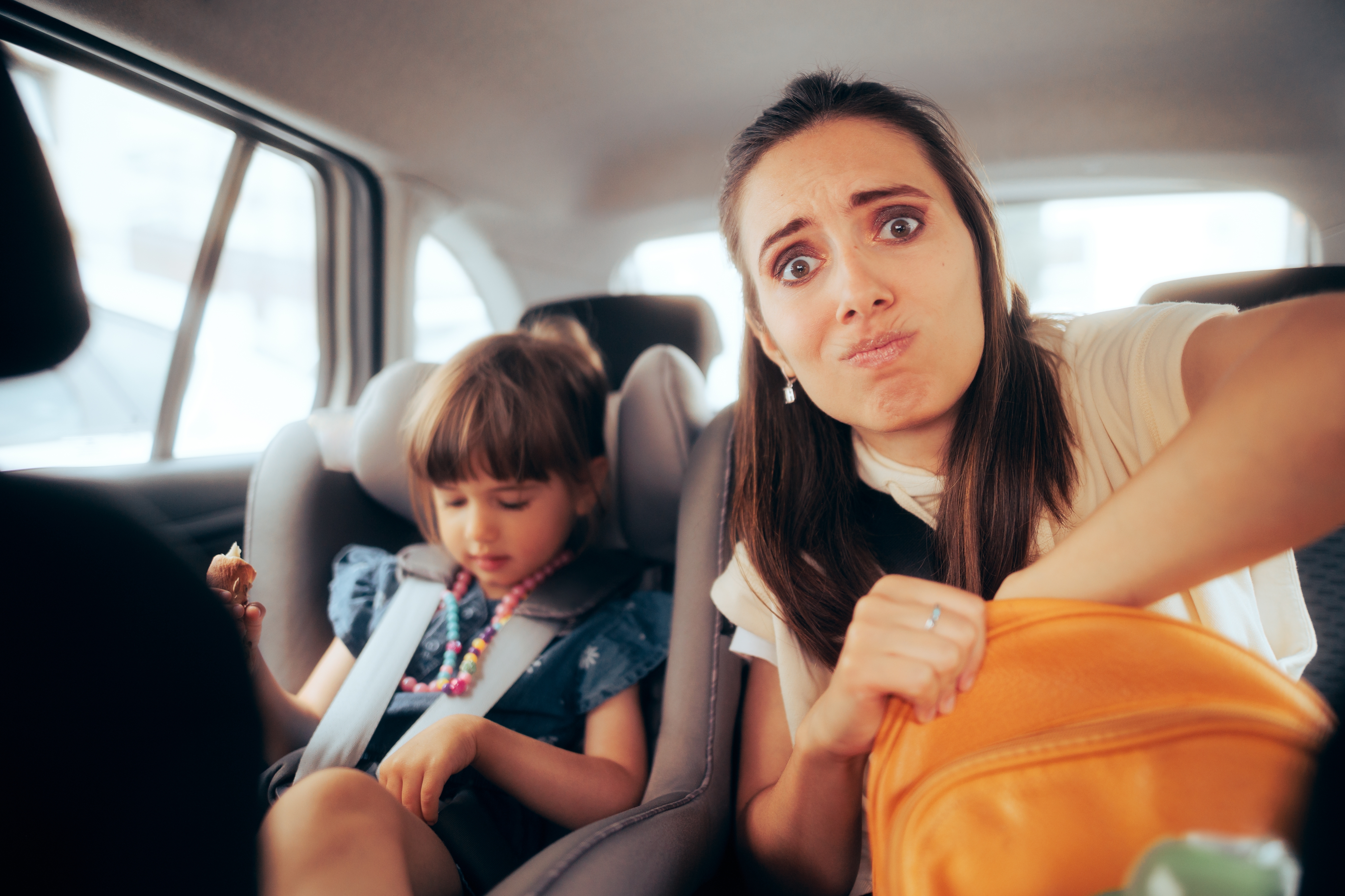 Una mujer estresada sentada en un Automóvil con una niña | Foto: Shutterstock