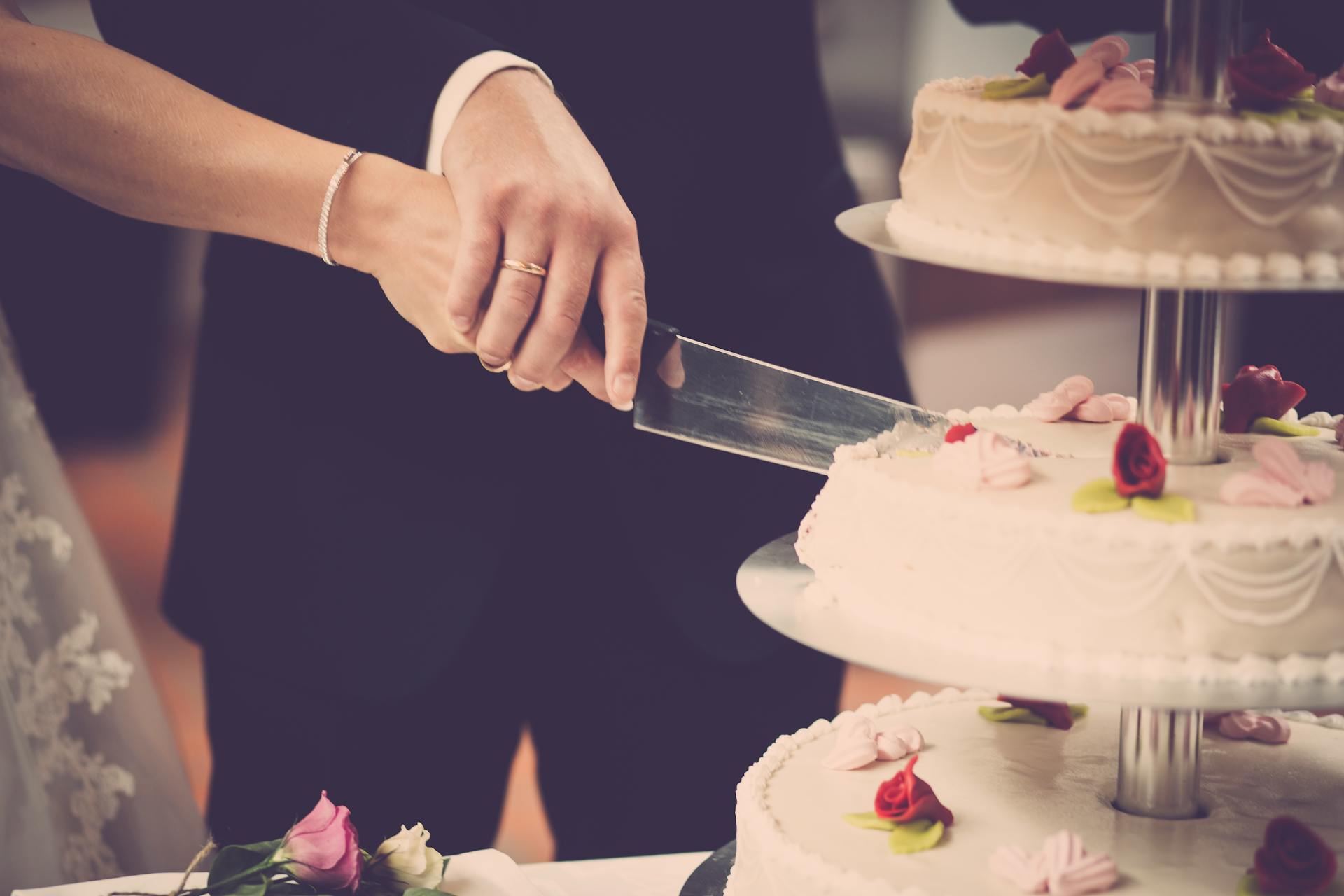 Una pareja cortando el Pastel el día de su boda | Fuente: Pexels