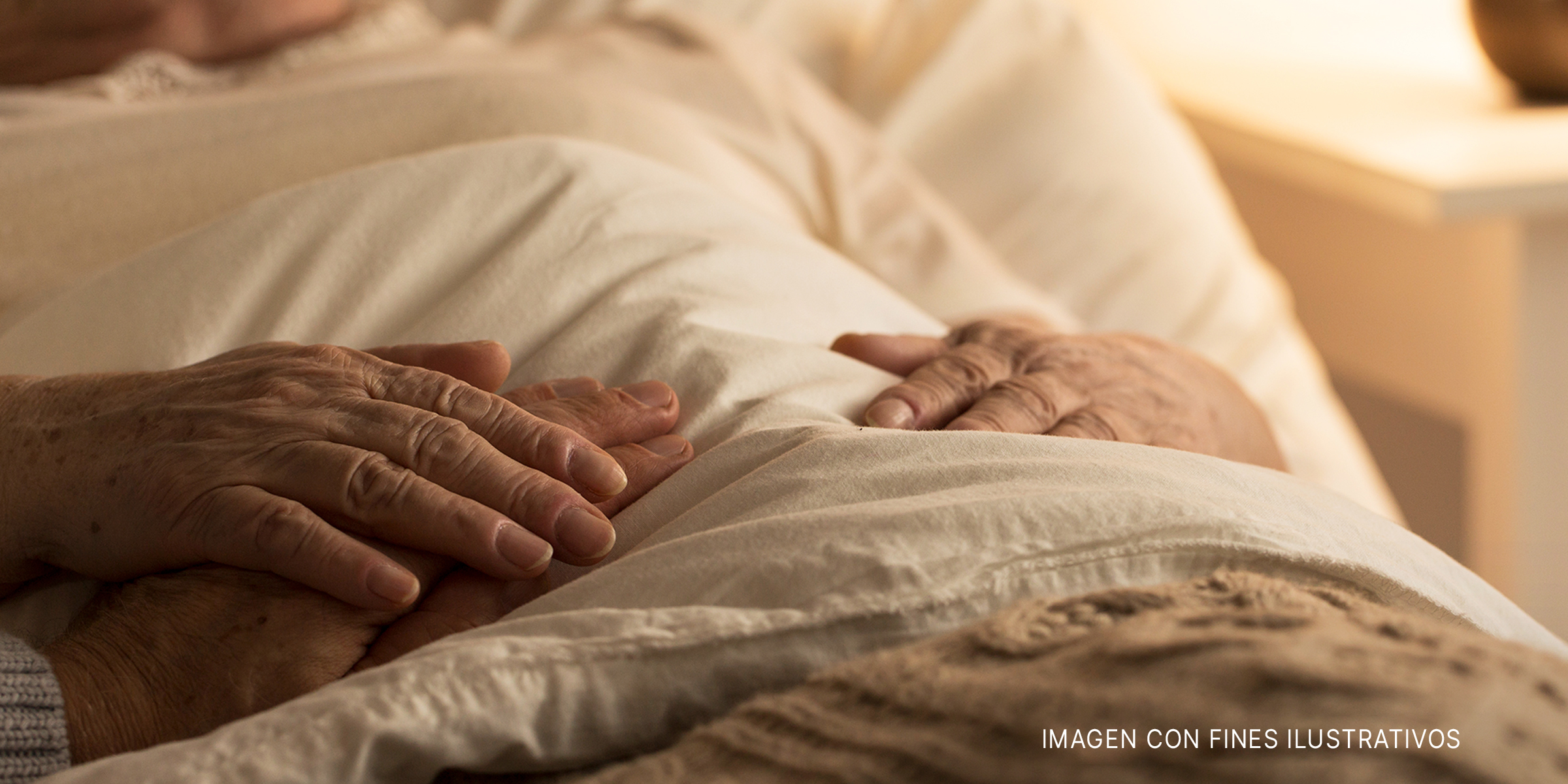 Manos apoyadas sobre las mantas en una cama de hospital. | Foto: Getty Images