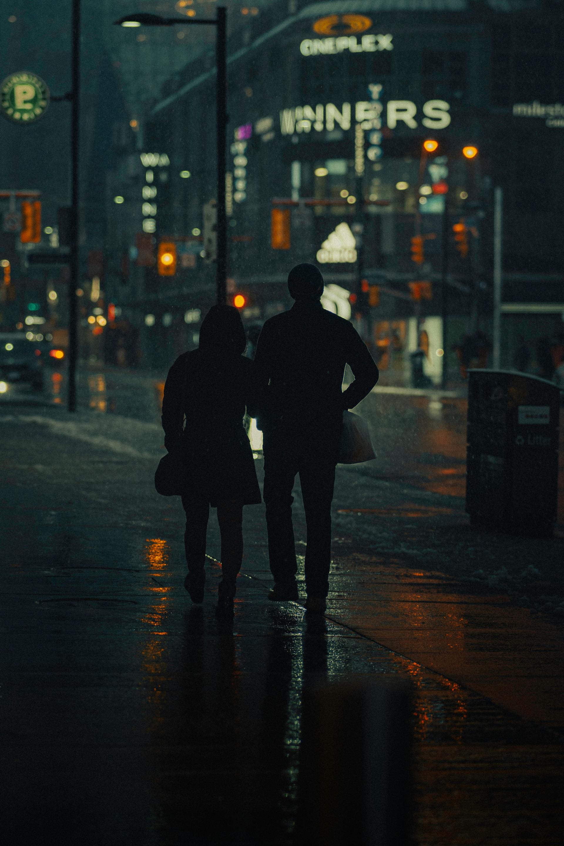 Silueta de una pareja caminando por la calle de noche | Fuente: Pexels