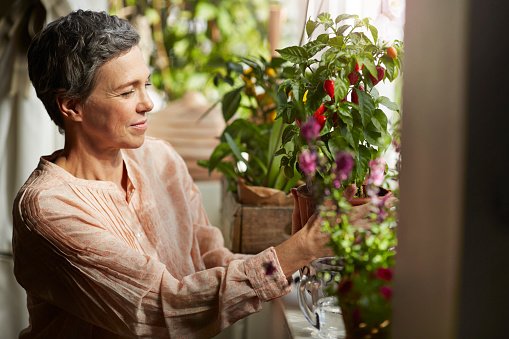 Mujer madura interactúa con plantas. │Foto: Getty Images
