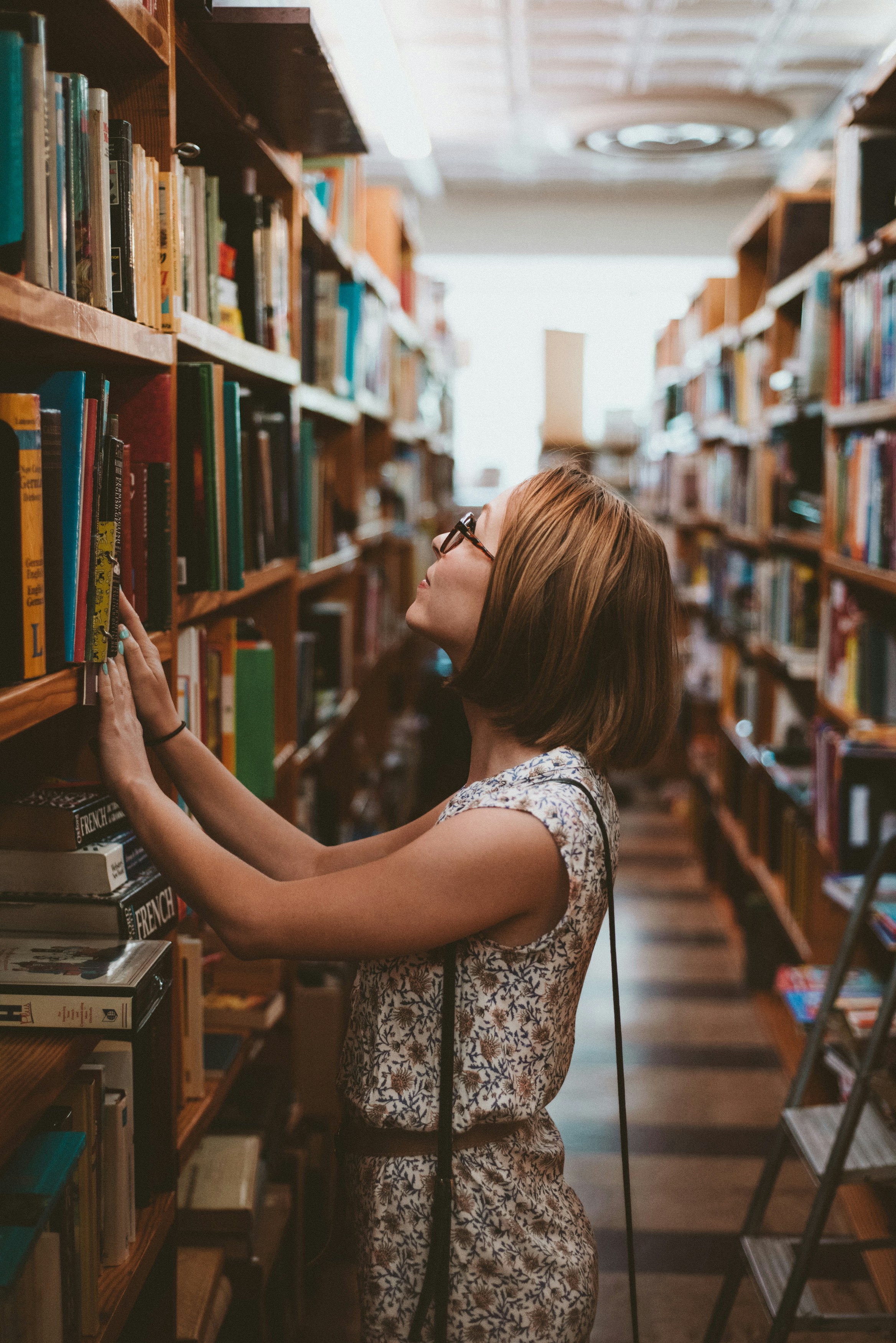 Una mujer busca un libro en una biblioteca | Fuente: Unsplash