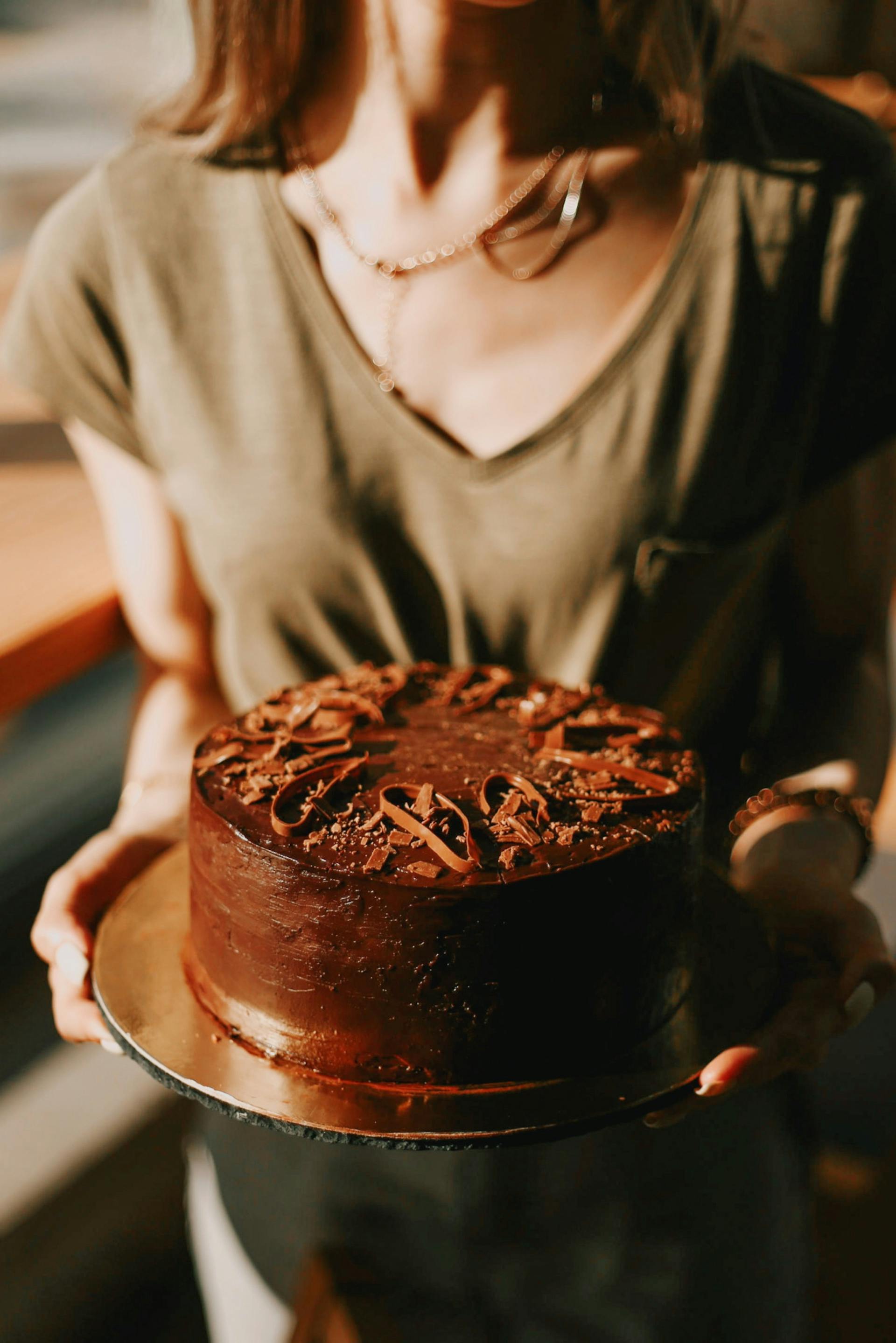 Primer plano de una mujer sujetando un pastel de chocolate | Fuente: Pexels