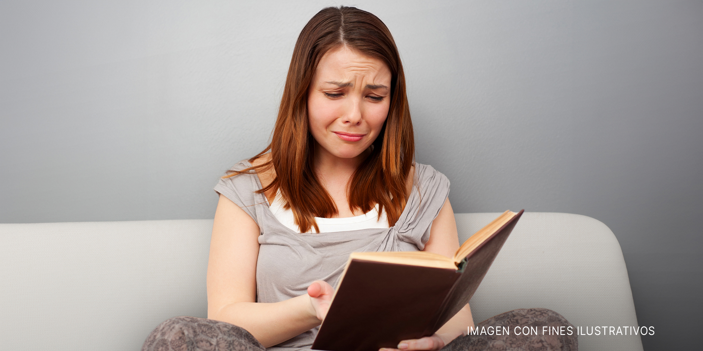Una mujer leyendo un libro y llorando | Foto: Shutterstock