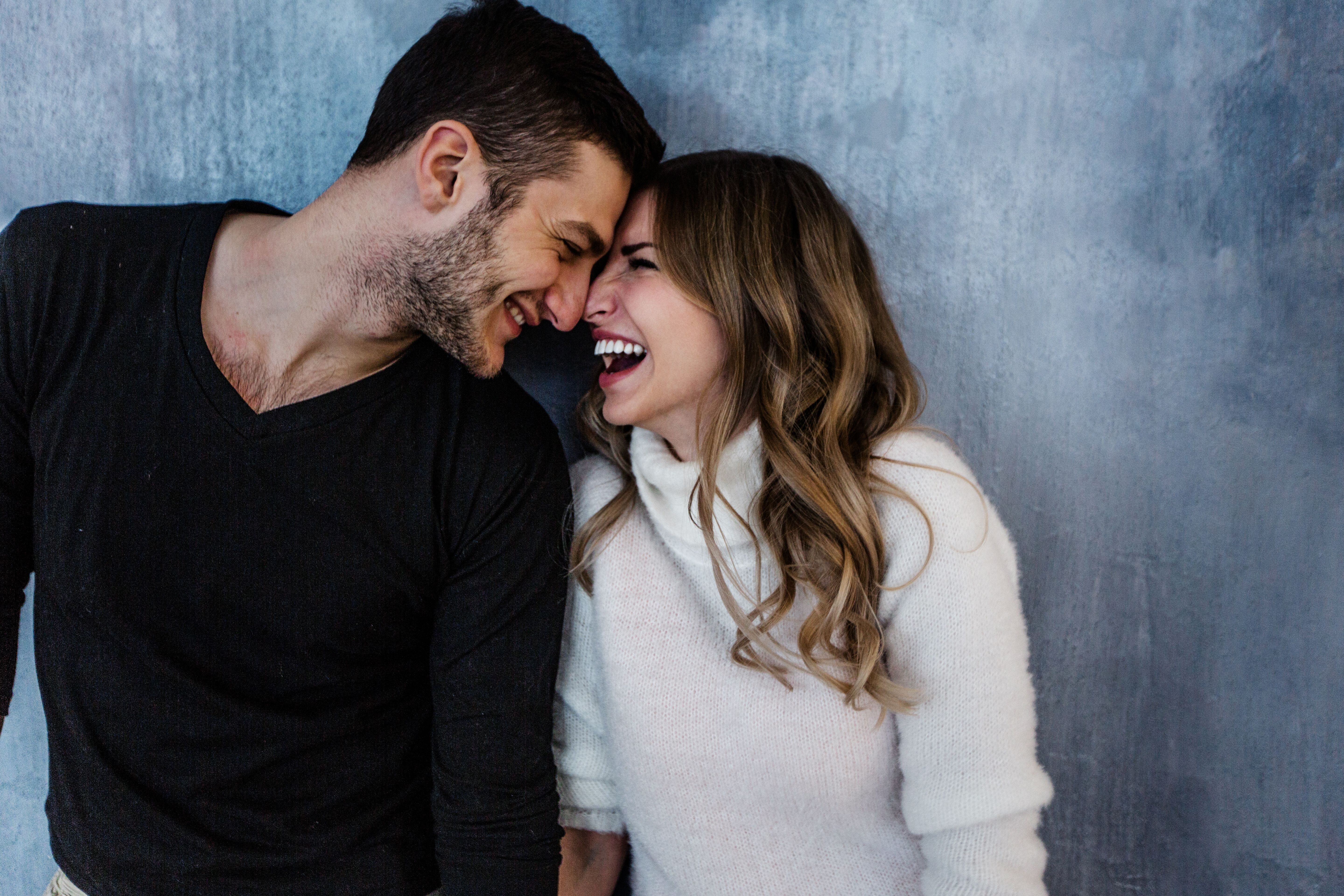 Un hombre y una mujer sonriéndose con la frente en contacto | Fuente: Shutterstock