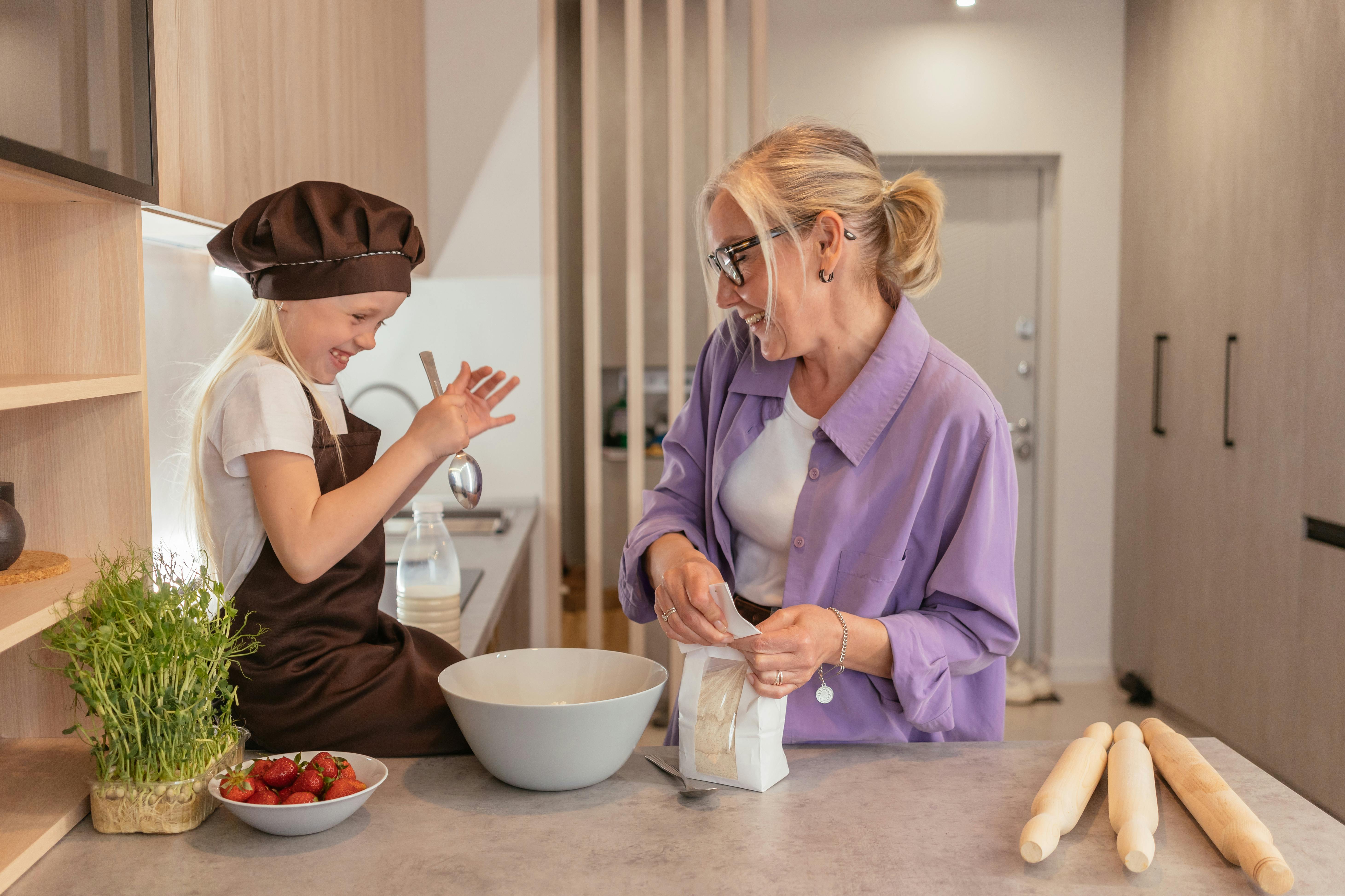 Una mujer cocinando con su nieta | Fuente: Pexels