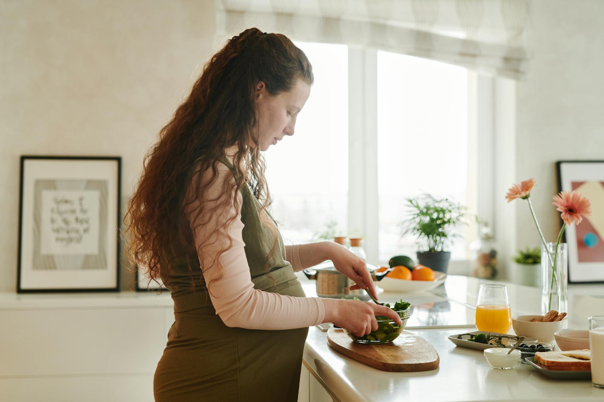 Una mujer embarazada preparando comida en la encimera de la cocina | Fuente: Pexels