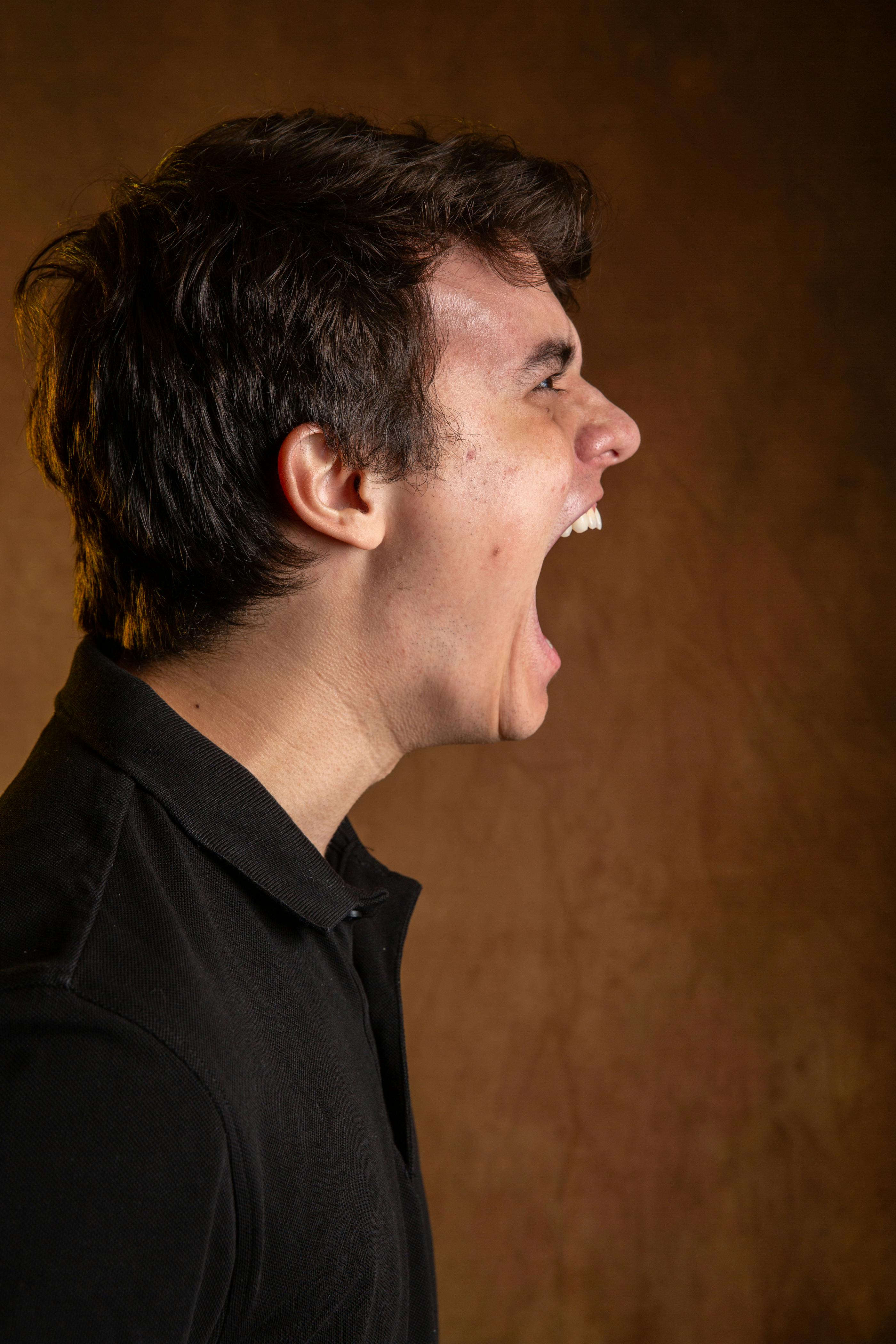 Un hombre con la boca muy abierta mientras grita a alguien | Foto: Pexels