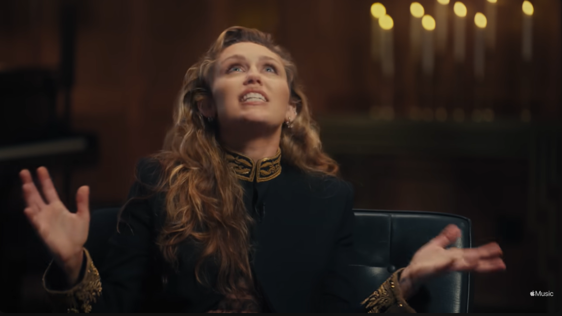 Miley Cyrus gesticula expresivamente durante su entrevista en Apple Music, abriéndose sobre el costo personal que hay detrás de su fuerza vocal | Fuente: YouTube/AppleMusic