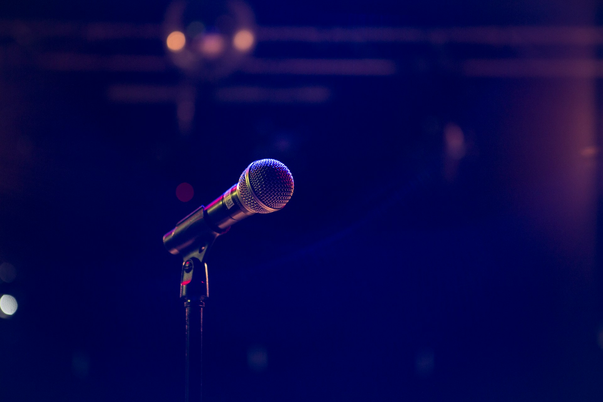 Un micro en el escenario bañado por una suave luz de estudio | Fuente: Unsplash