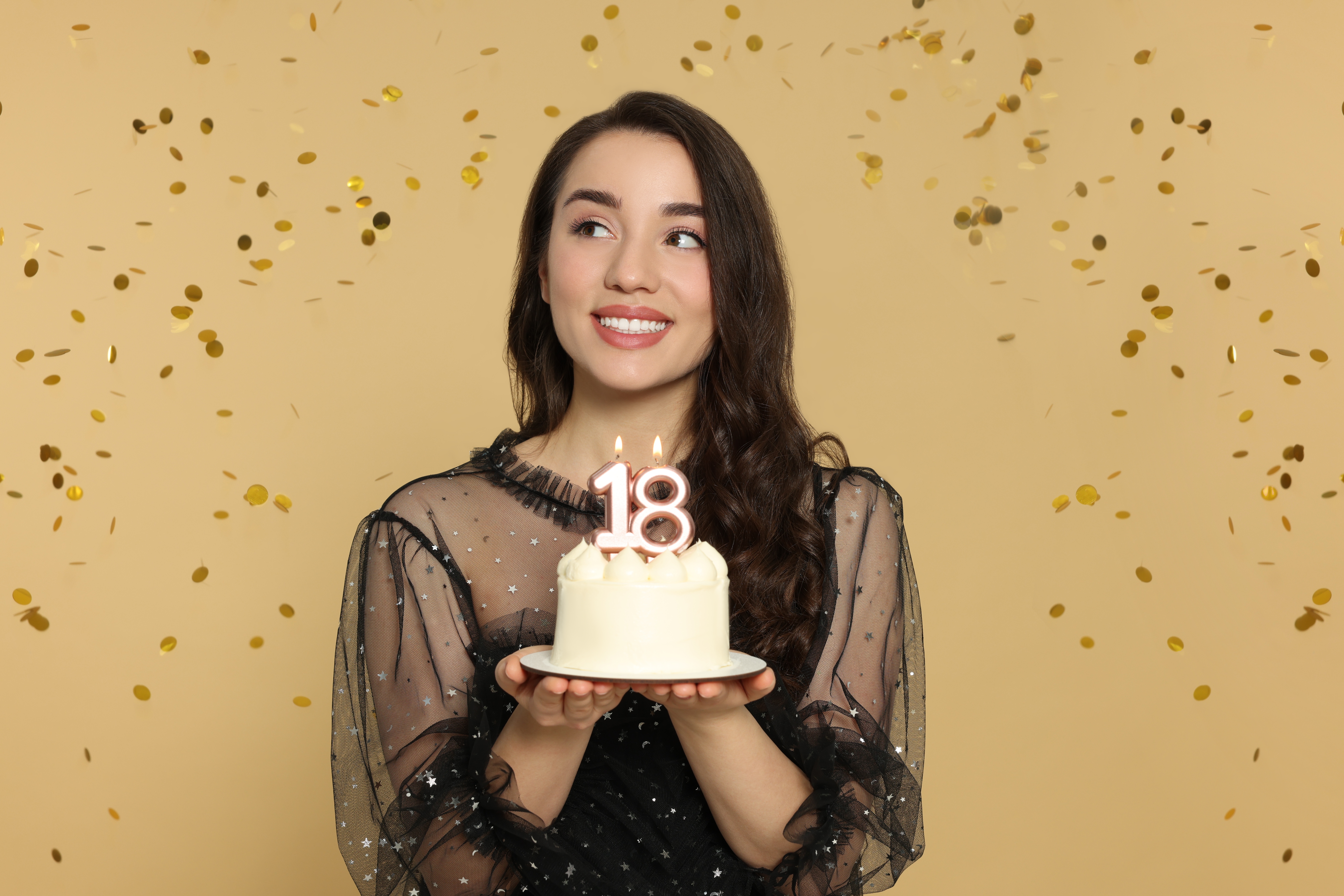 Joven sosteniendo su pastel de 18 cumpleaños | Foto: Shutterstock