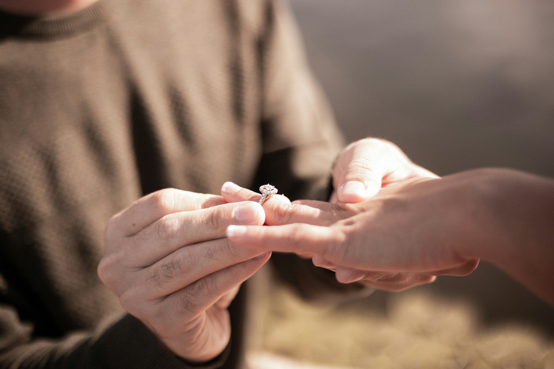 Primer plano recortado de un hombre deslizando un anillo en el dedo de una mujer | Fuente: Unsplash