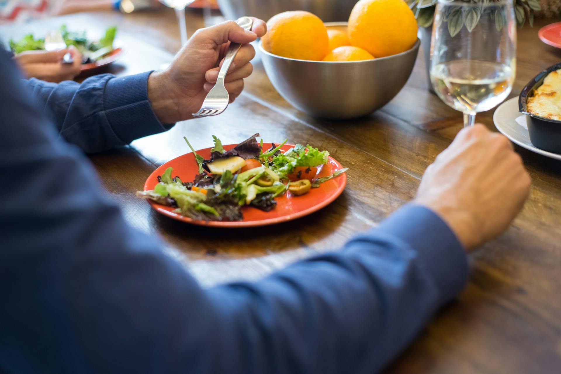 Una persona sentada en una mesa comiendo ensalada | Fuente: Pexels