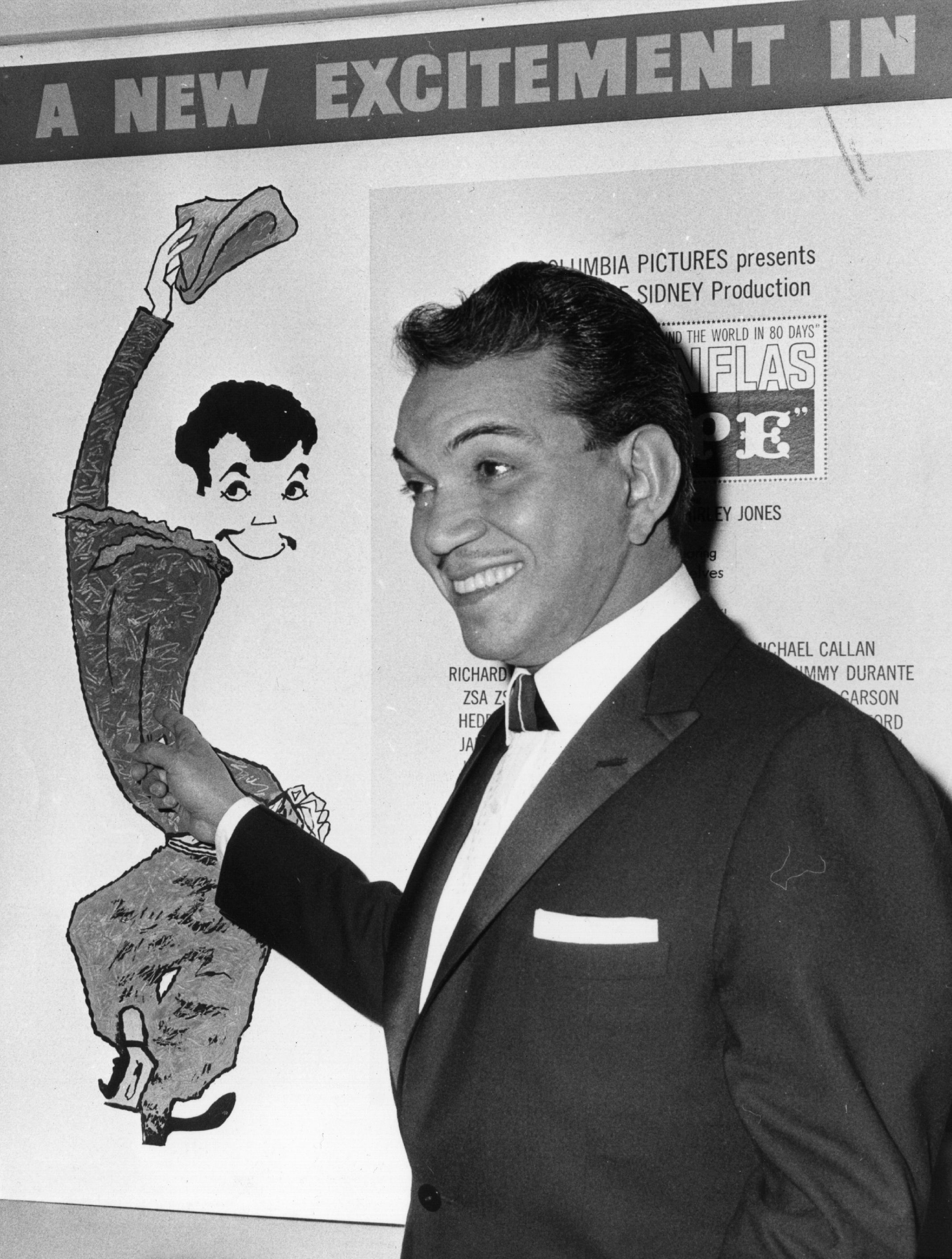 Cantinflas señala orgulloso un afiche de sí mismo en el cine Columbia de la avenida Shaftestbury en Londres, en febrero de 1961 || Foto: Getty Images