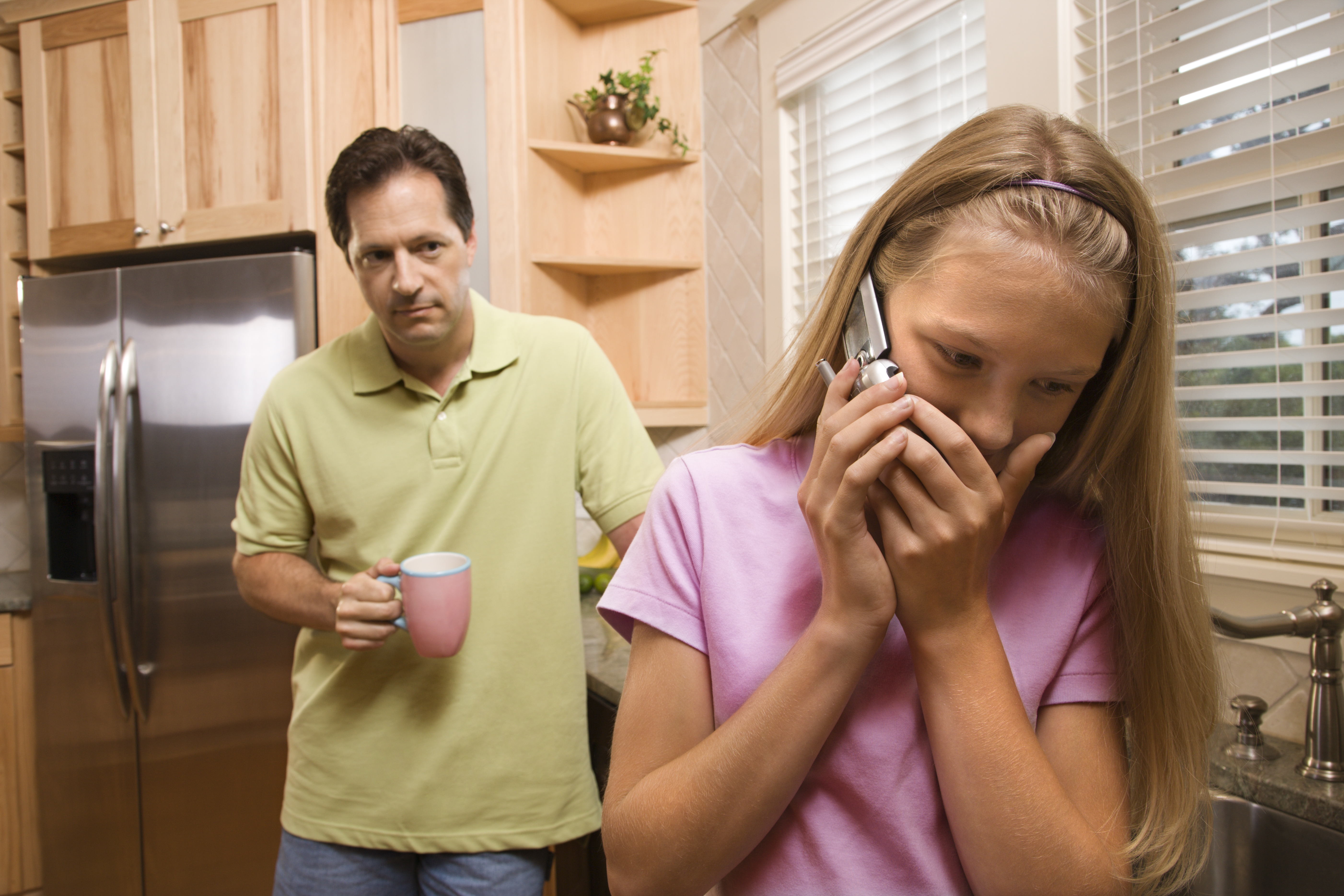 Un hombre observa a una joven hablando por teléfono | Fuente: Shutterstock