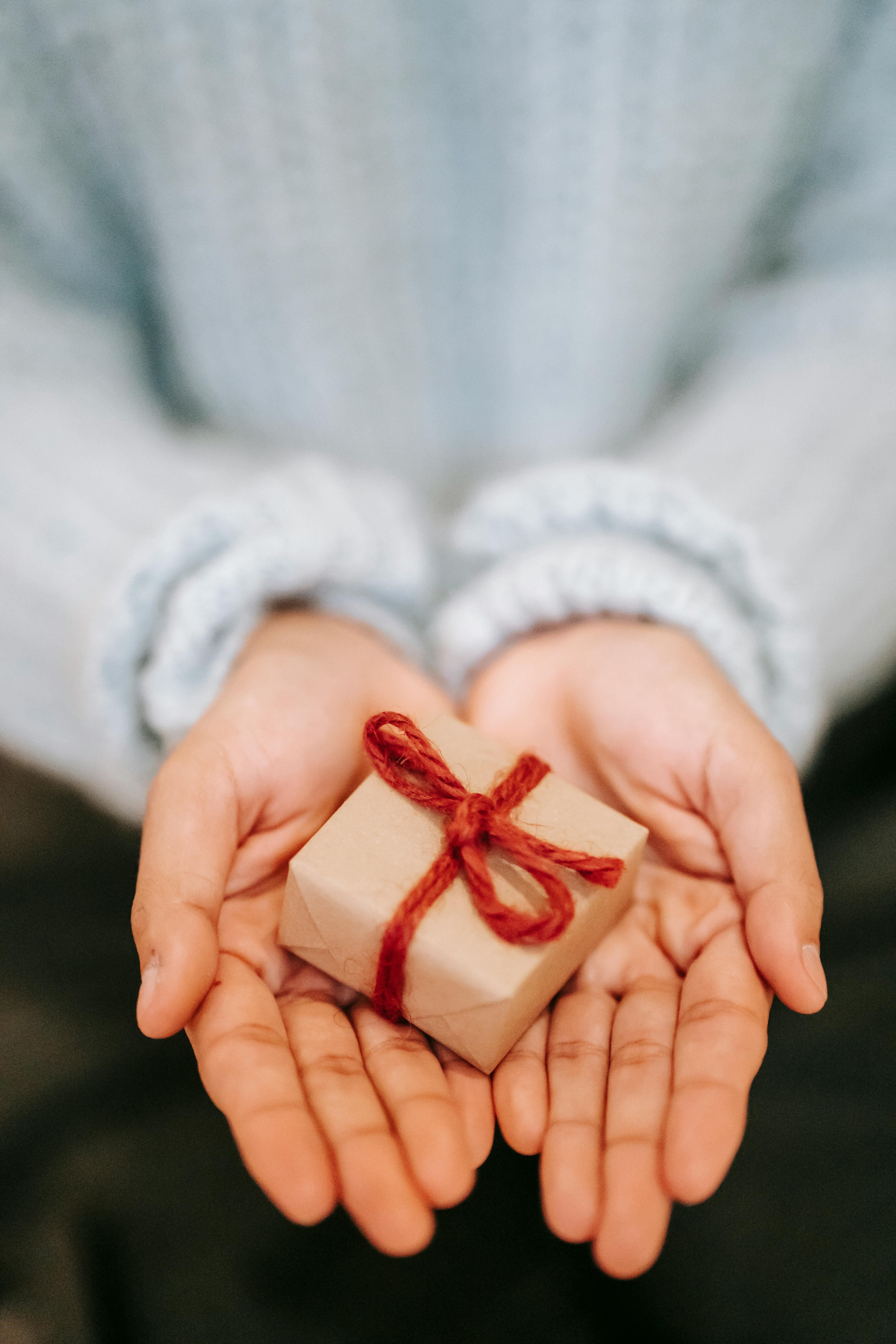 Una mujer sostiene una pequeña caja envuelta | Fuente: Pexels