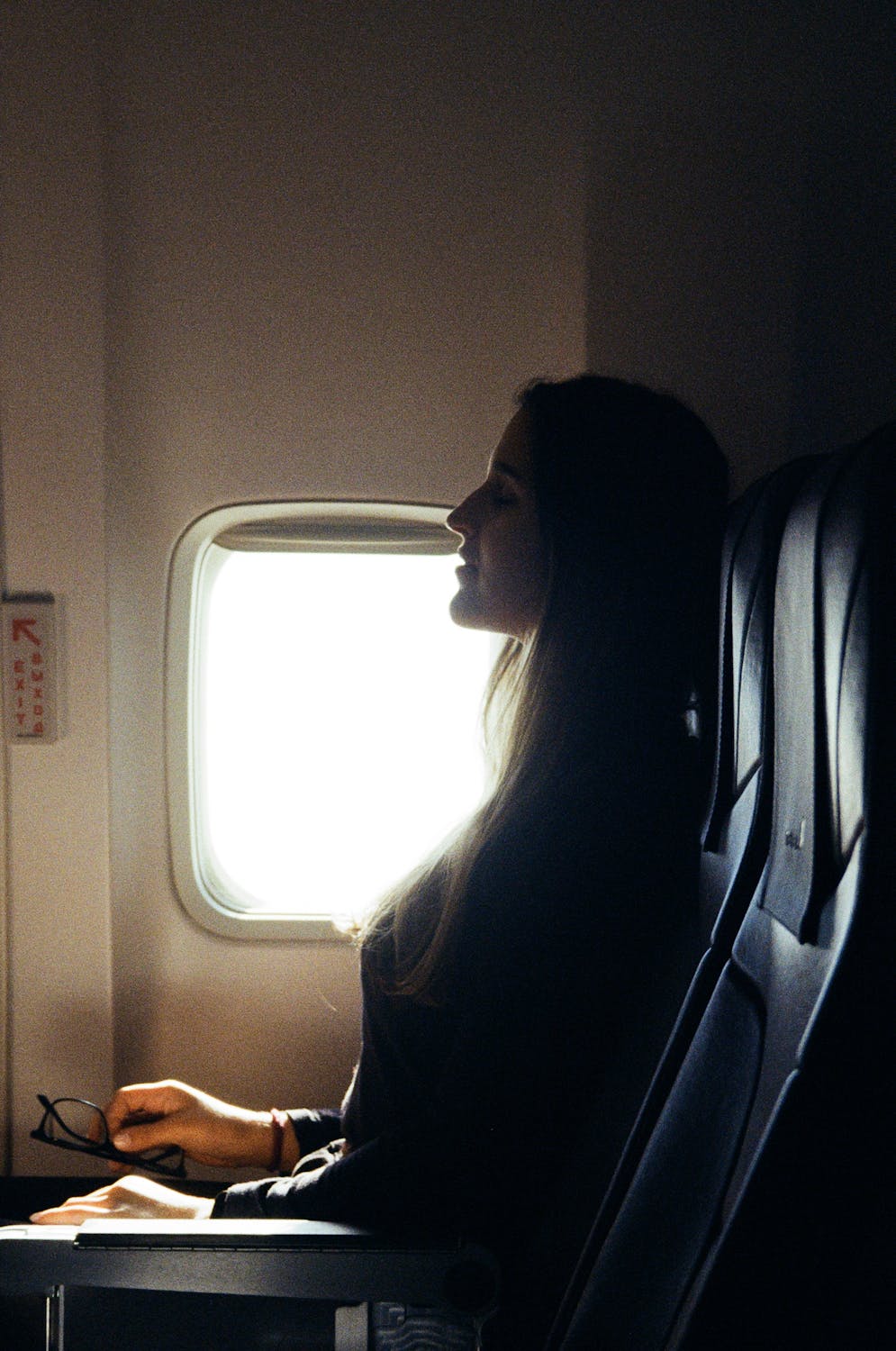 Una mujer acomodándose en su asiento de la ventana | Fuente: Pexels