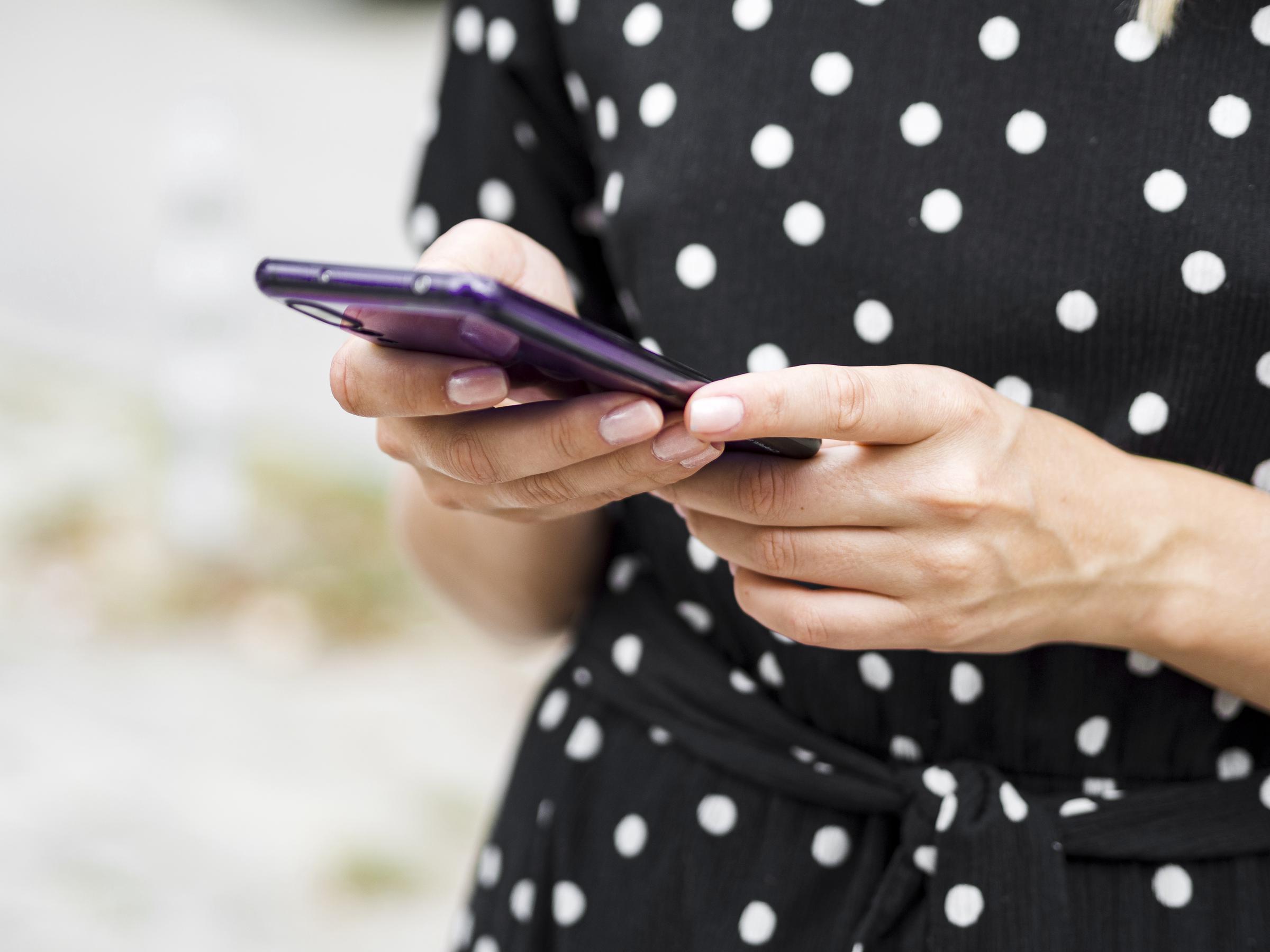 Una mujer tecleando un mensaje en su teléfono | Fuente: Freepik