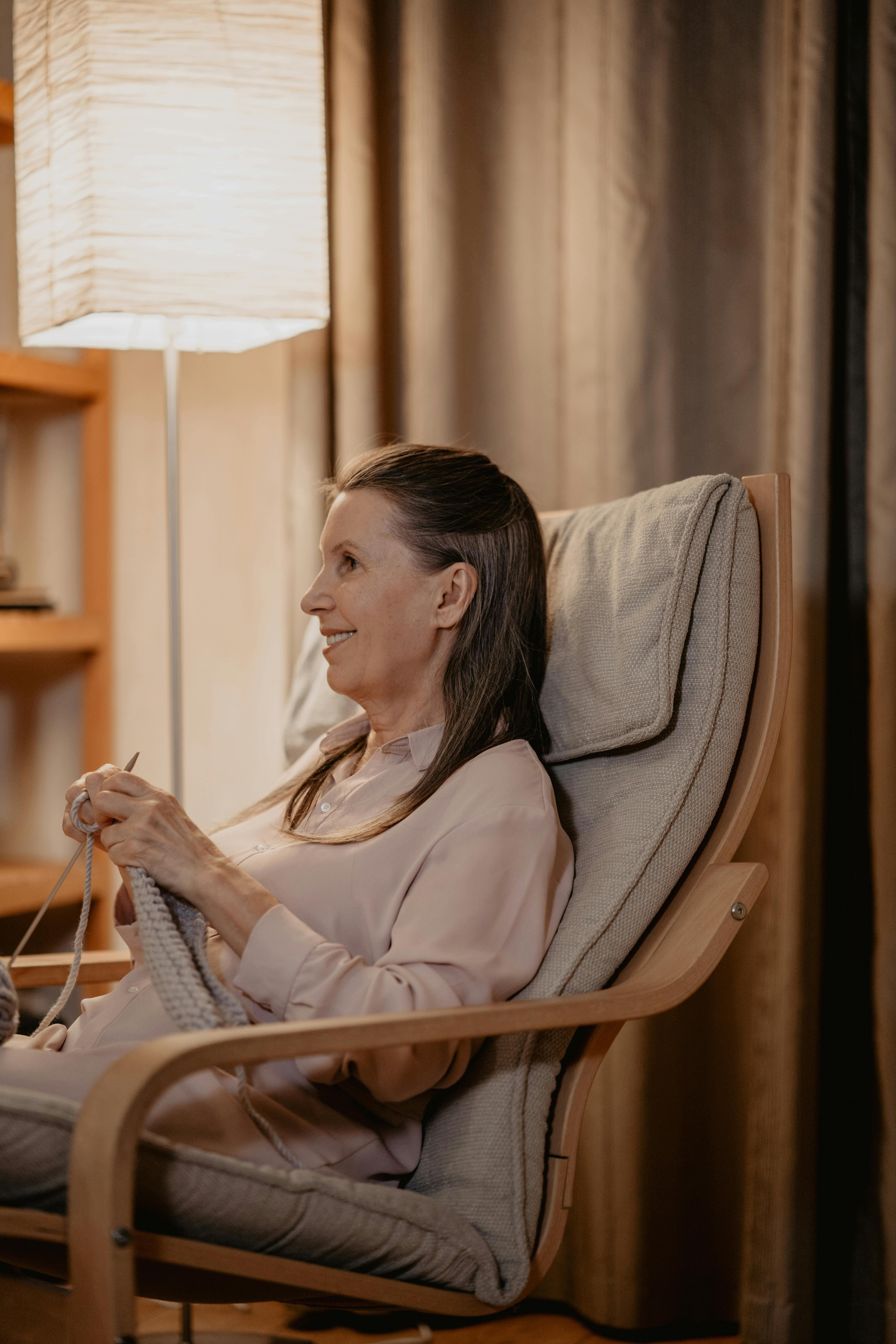 Anciana sentada en una silla tejiendo | Fuente: Pexels