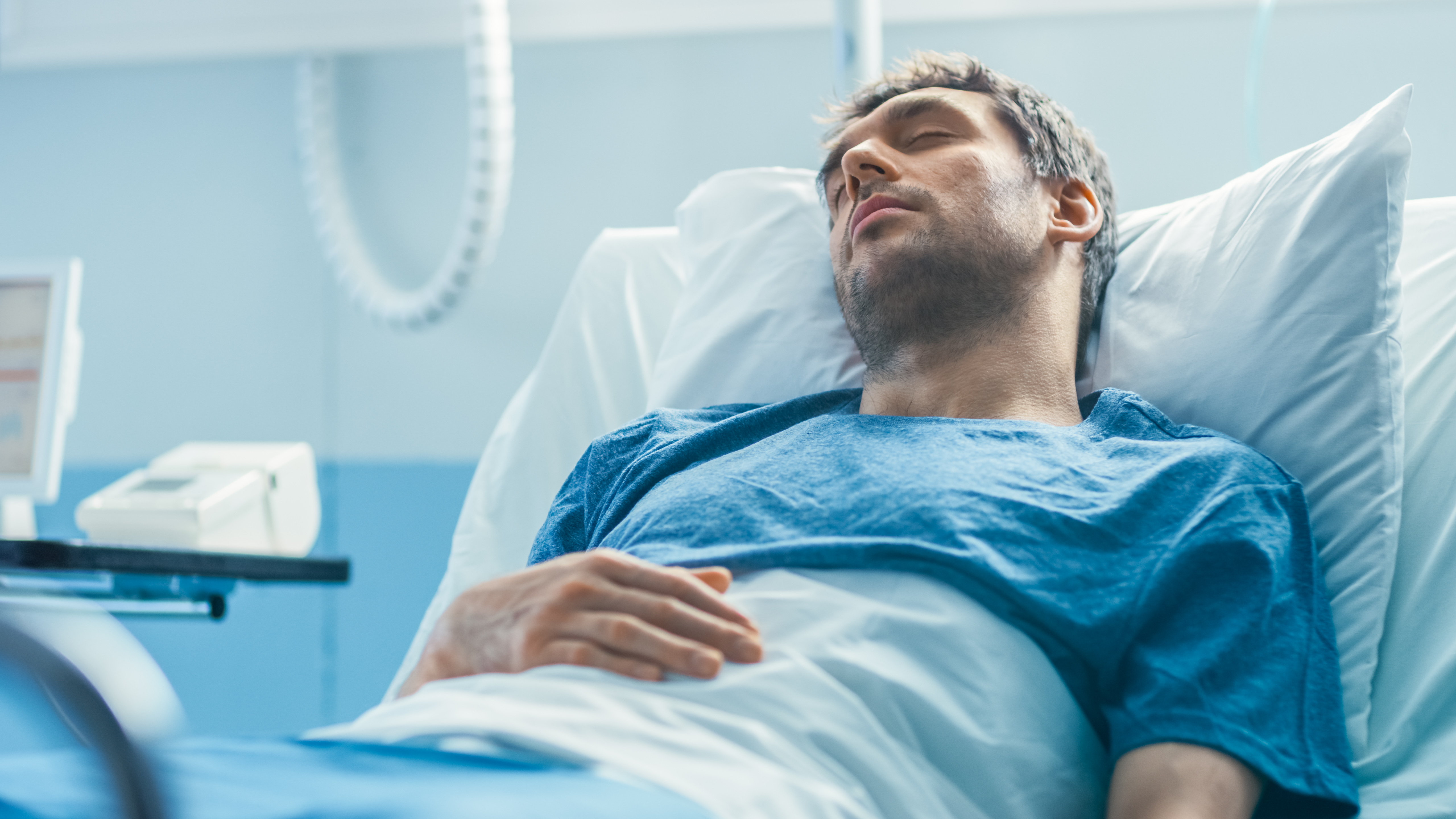 Un hombre duerme en la cama de un hospital | Fuente: Shutterstock.com